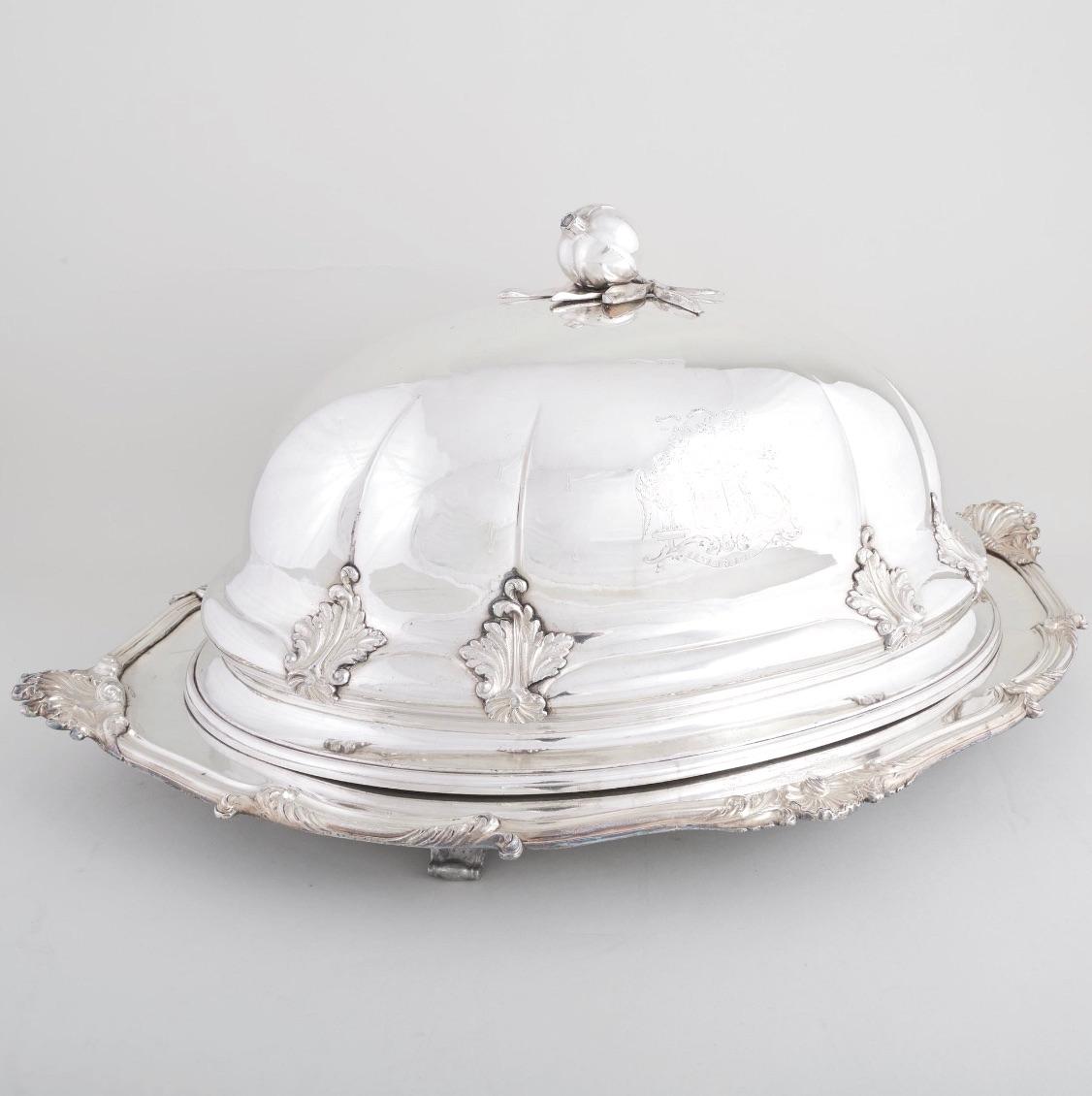Esta impresionante vajilla de plata inglesa antigua combina elegancia y funcionalidad, perfecta para las grandes ocasiones. El juego de dos piezas incluye una tapa ovalada y una bandeja calientaplatos a juego, ambas con una artesanía excepcional y