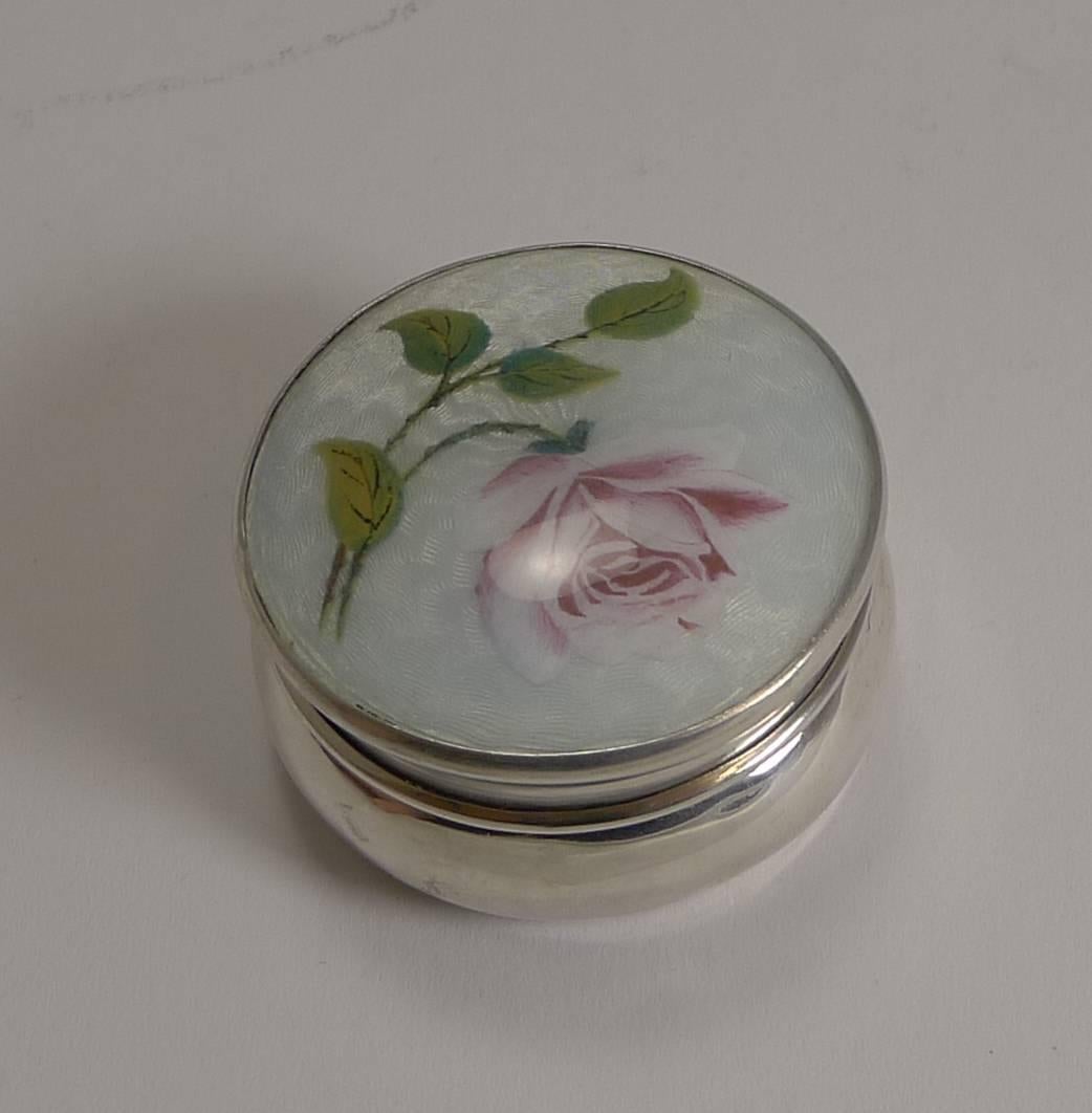 Pretty as a picture, this antique pill box is beautifully shaped and topped with the most attractive guilloche enamel decoration incorporating a romantic hand painted pink rose.

The lid lifts and reveals a lavishly gilded interior.

The silver