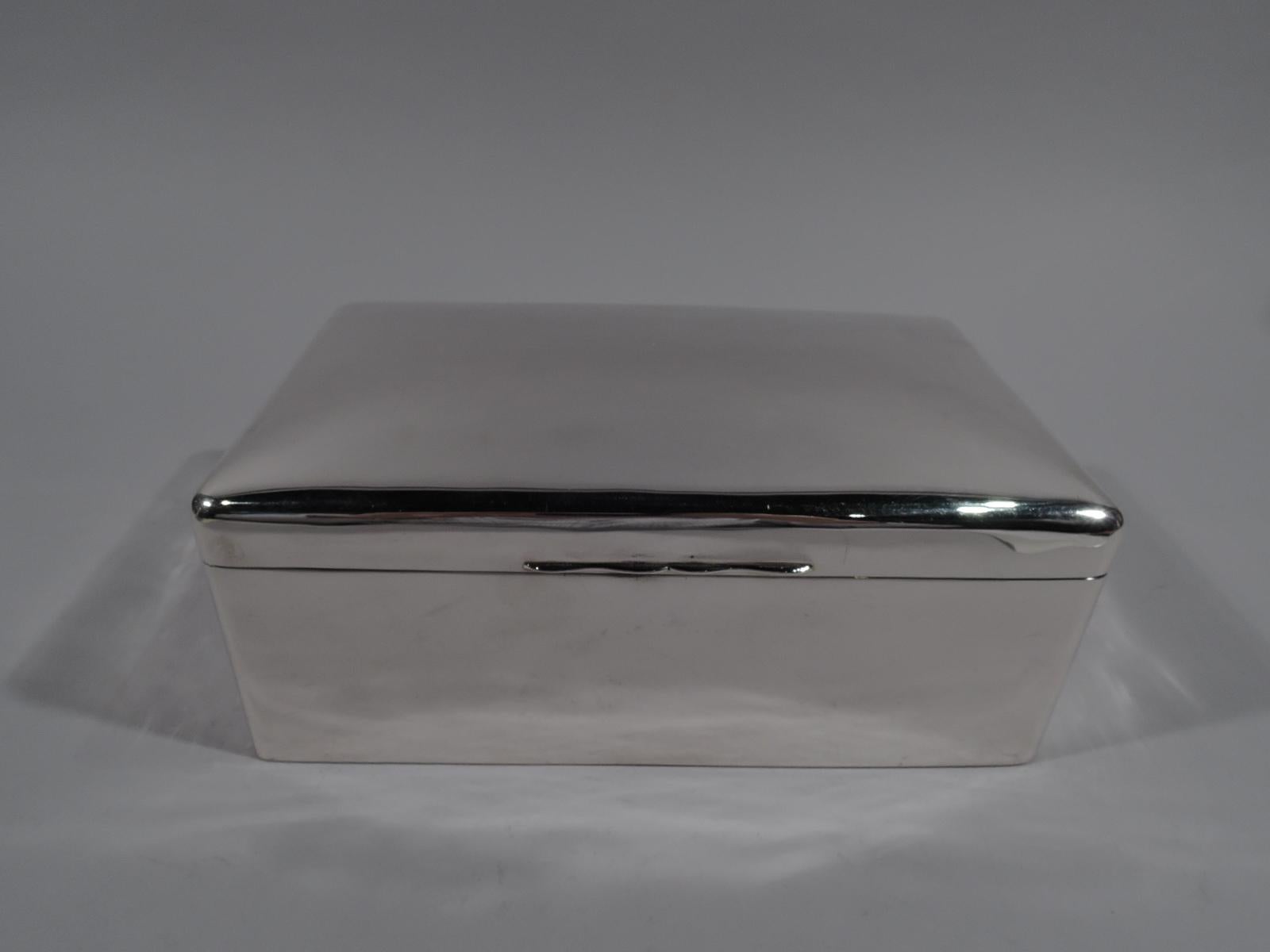 Large English sterling silver box, 1919. Rectangular with curved corners. Cover flat, hinged, and tabbed. Box interior cedar lined and partitioned. Underside leather-lined. Cover interior gilt washed. A capacious receptacle. Fully marked including