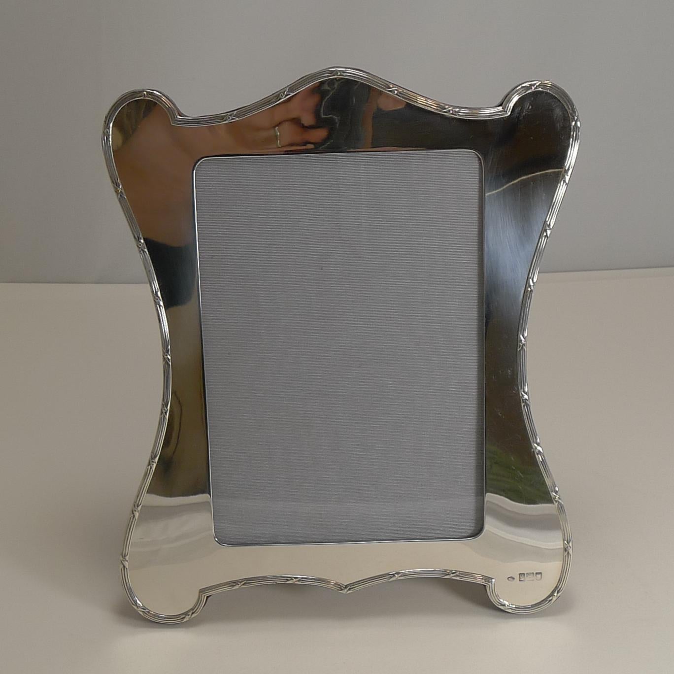 A fabulous large Edwardian photograph frame, wonderful quality and condition.

Made from English sterling silver, this shaped frame has an understated elegance with a simple ribbon and reed border showcasing the shape. The silver is fully
