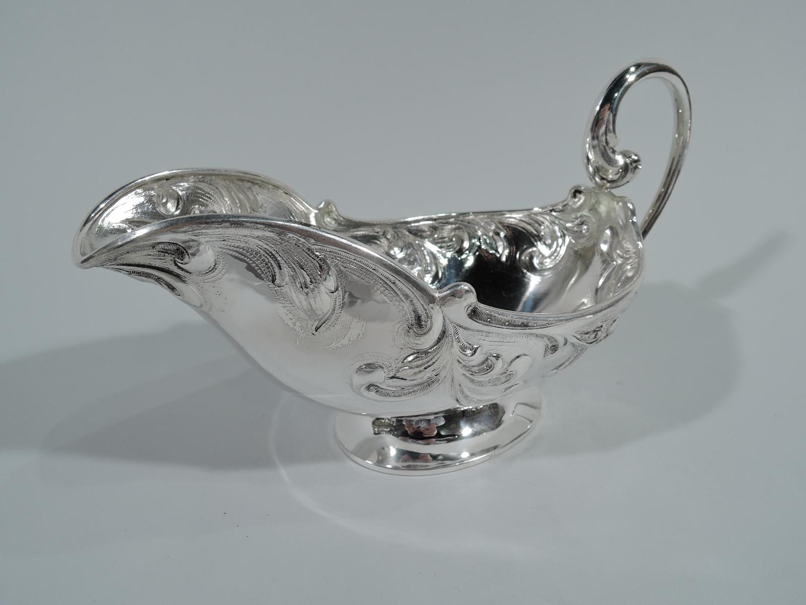 Antique European 835 silver gravy boat. Large and wide with fluid scrollwork heightened with stippling, high-looping scroll handle, and raised oval foot. Hallmarked. Weight: 12.6 troy ounces.