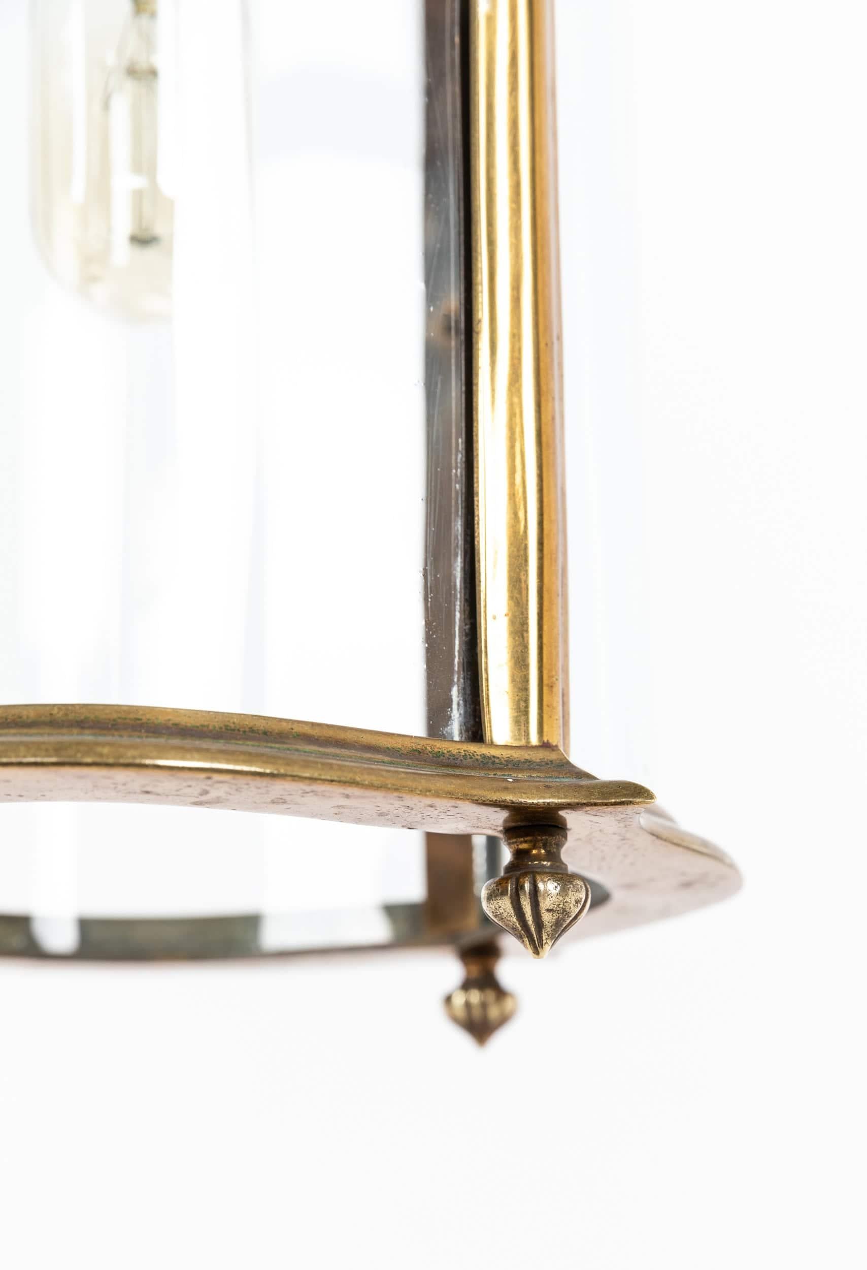 A beautifully formed brass porch/hall lantern made by Faraday & Son. c.1920

Of larger form, crafted from brass to the highest standard, still retaining remnants of the gilt finish. Curved glazed panels all original and intact. Period gilt chain