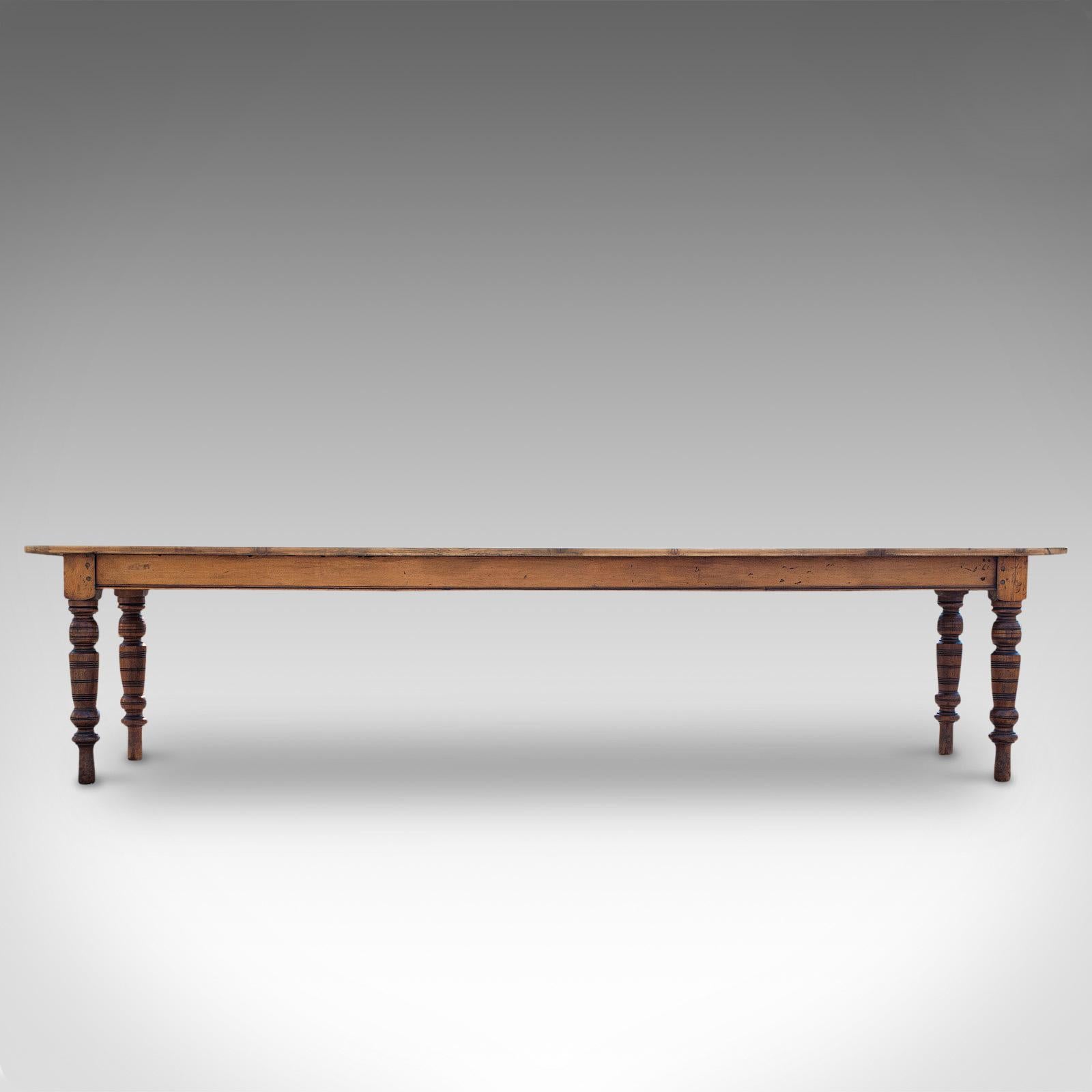 This is a large antique farmhouse table. An English, pine over mahogany kitchen or dining table for 10-12 people, dating to the Victorian period and later, circa 1900.

Of long and narrow proportion at 10' 4