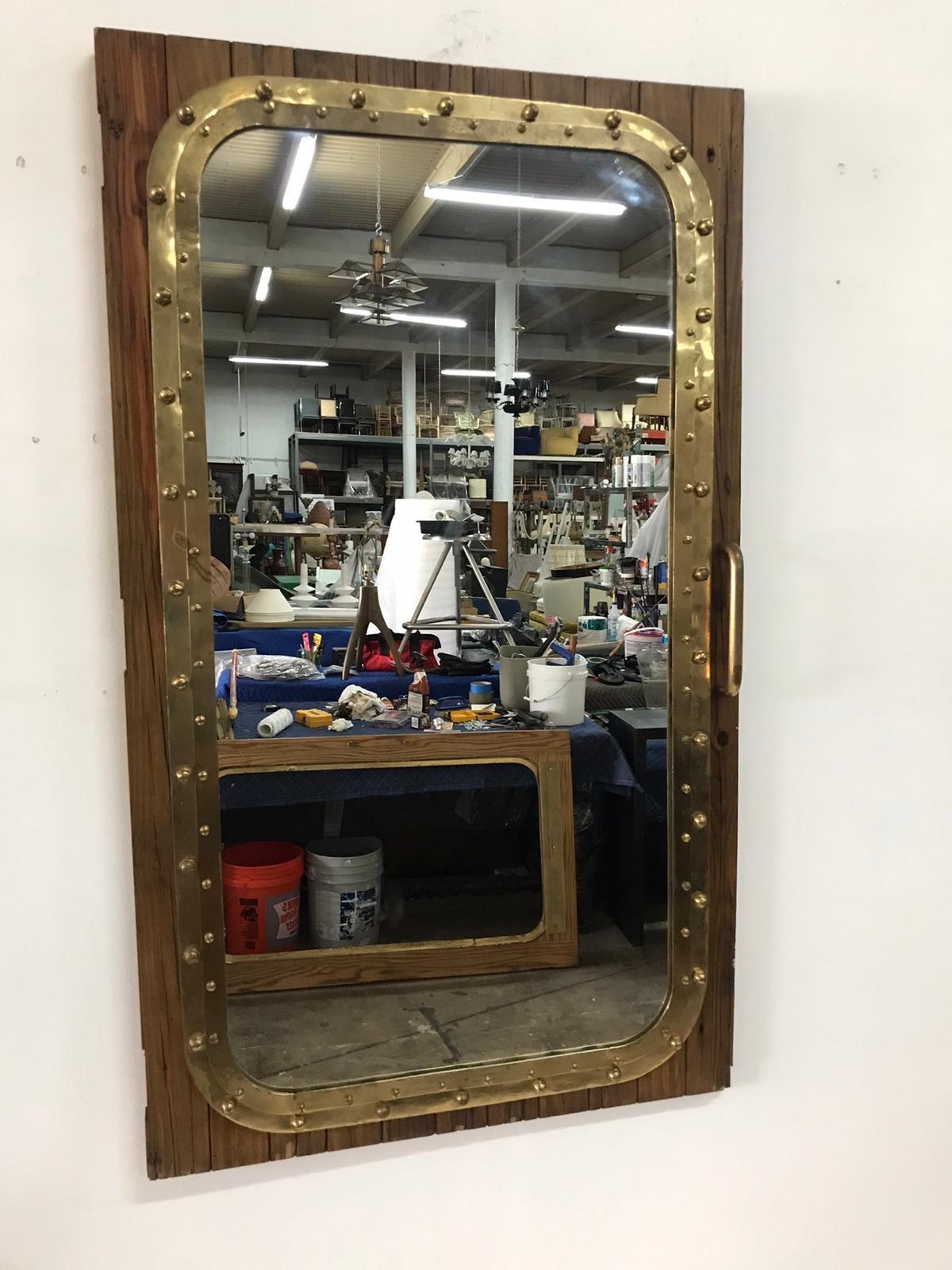 One of two, almost identical windows repurposed into mirrors, this pair of bronze and oak architectural remnants rescued from a shipyard on the Miami River. Antique and very large with original oakwood patina. We removed the hinges but left the