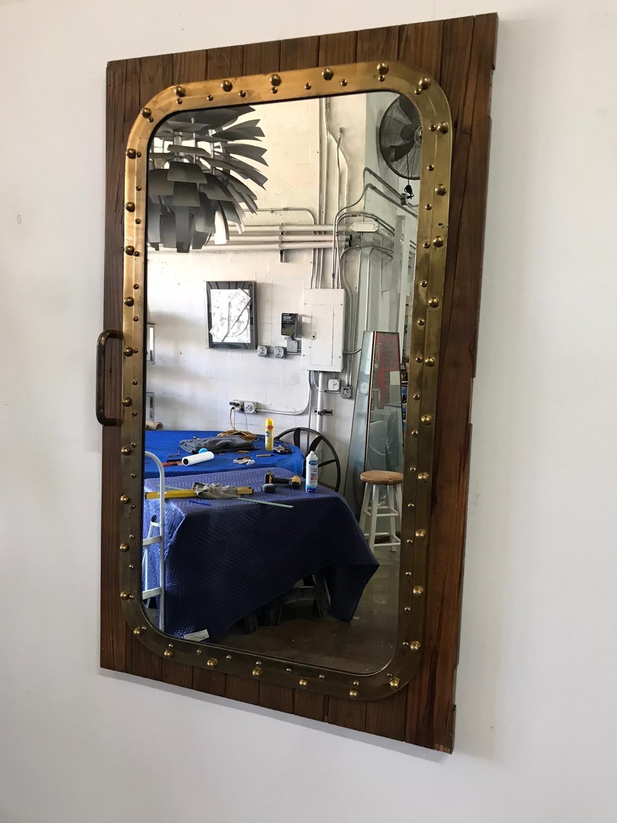 One of two, almost identical windows repurposed into mirrors, this pair of bronze and oak architectural remnants rescued from a shipyard on the Miami River. Antique and very large with original oak wood patina. We removed the hinges but left the