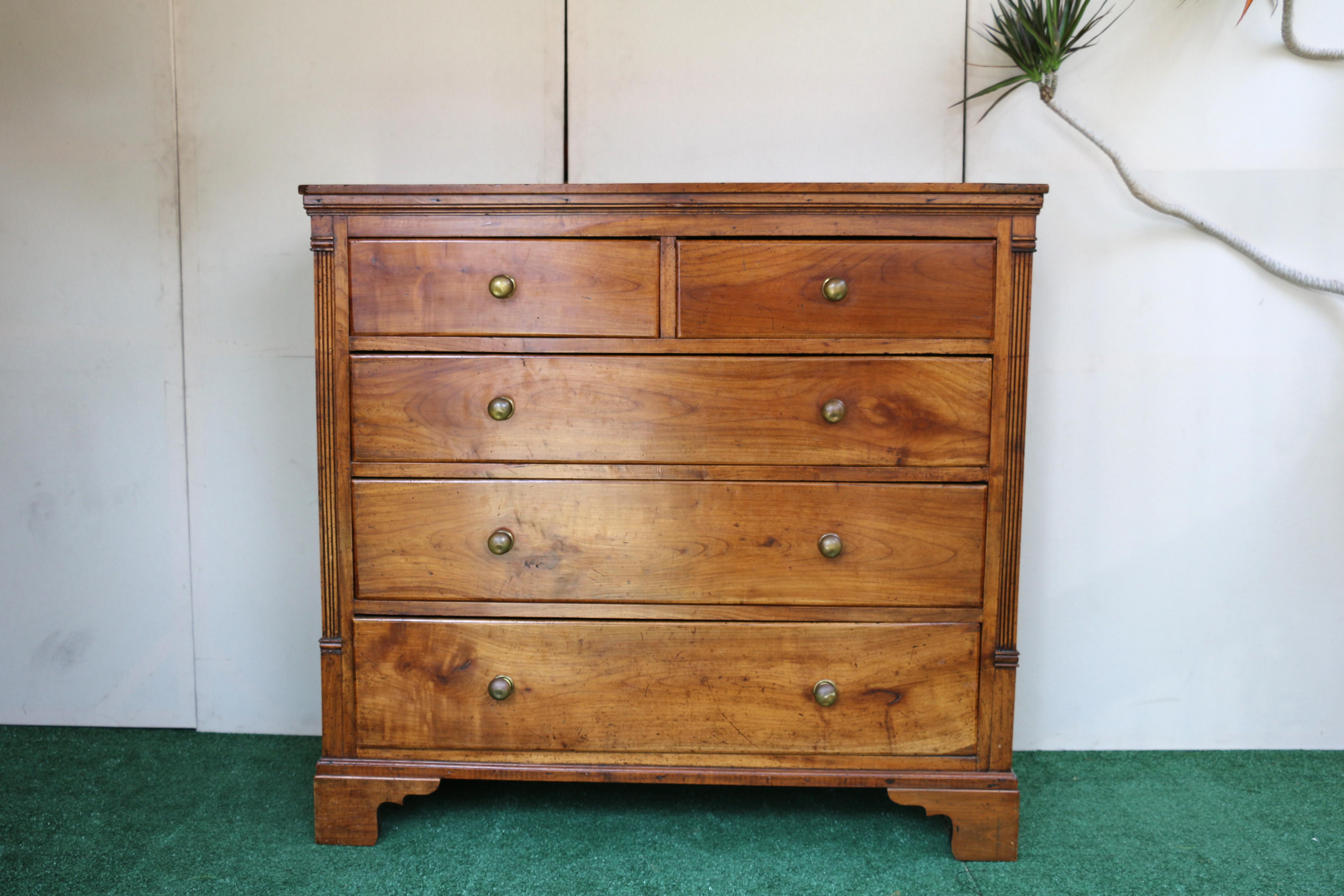 Wonderful chest of drawers. This is an amazing antique piece made of fruitwood. It has a classic design with fluted pilasters on the sides and a stepped top edge. The chest includes multiple drawers with brass pull handles; specifically, there are