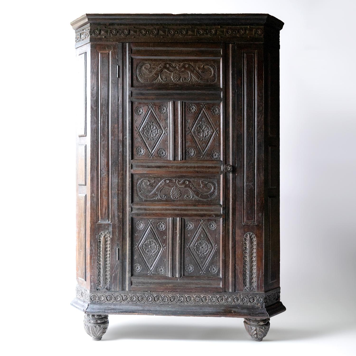 ANTIQUE PRIMITIVE OAK CORNER CUPBOARD 
A country-made piece with charming folk art style carving depicting stylised dolphins, roses and geometric patterns. 

Raised on bulbous, carved feet. 

Made from solid oak with a wonderfully rich patina.