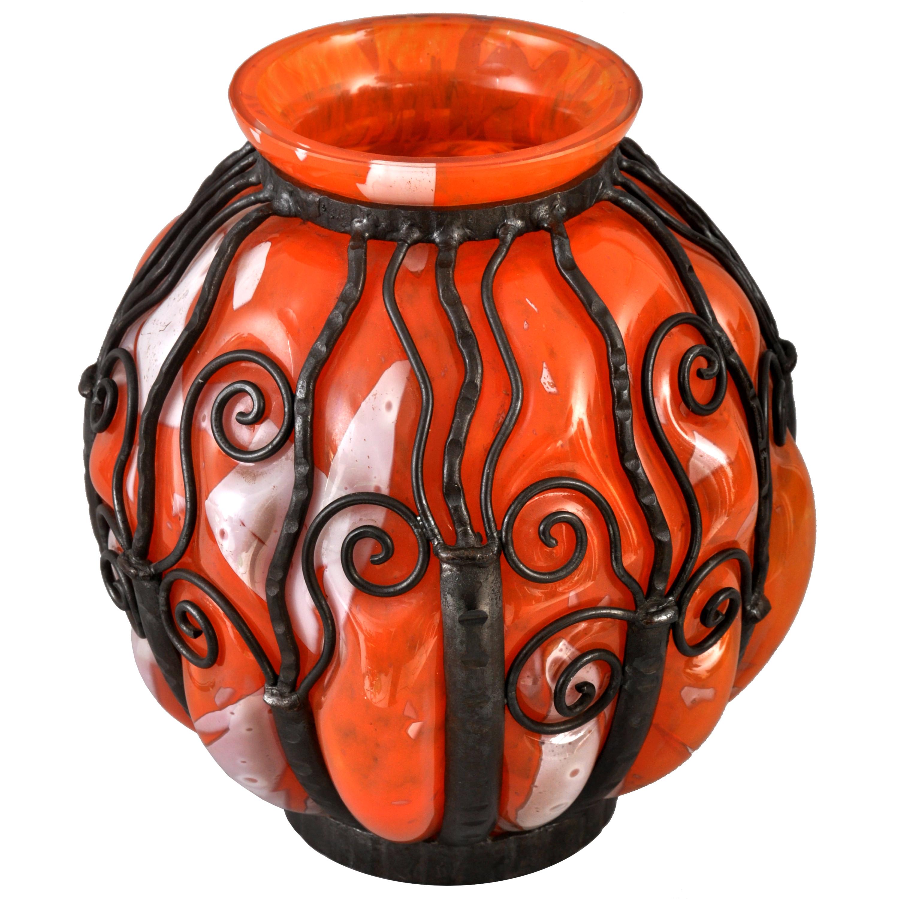 A very large French Art Deco glass and handwrought iron vase by Daum Verreries d'Art Lorrain, 1920s. The vase of very substantial size and having a mottled orange and cream glass vase, blown into hand forged iron armature. The vase is signed