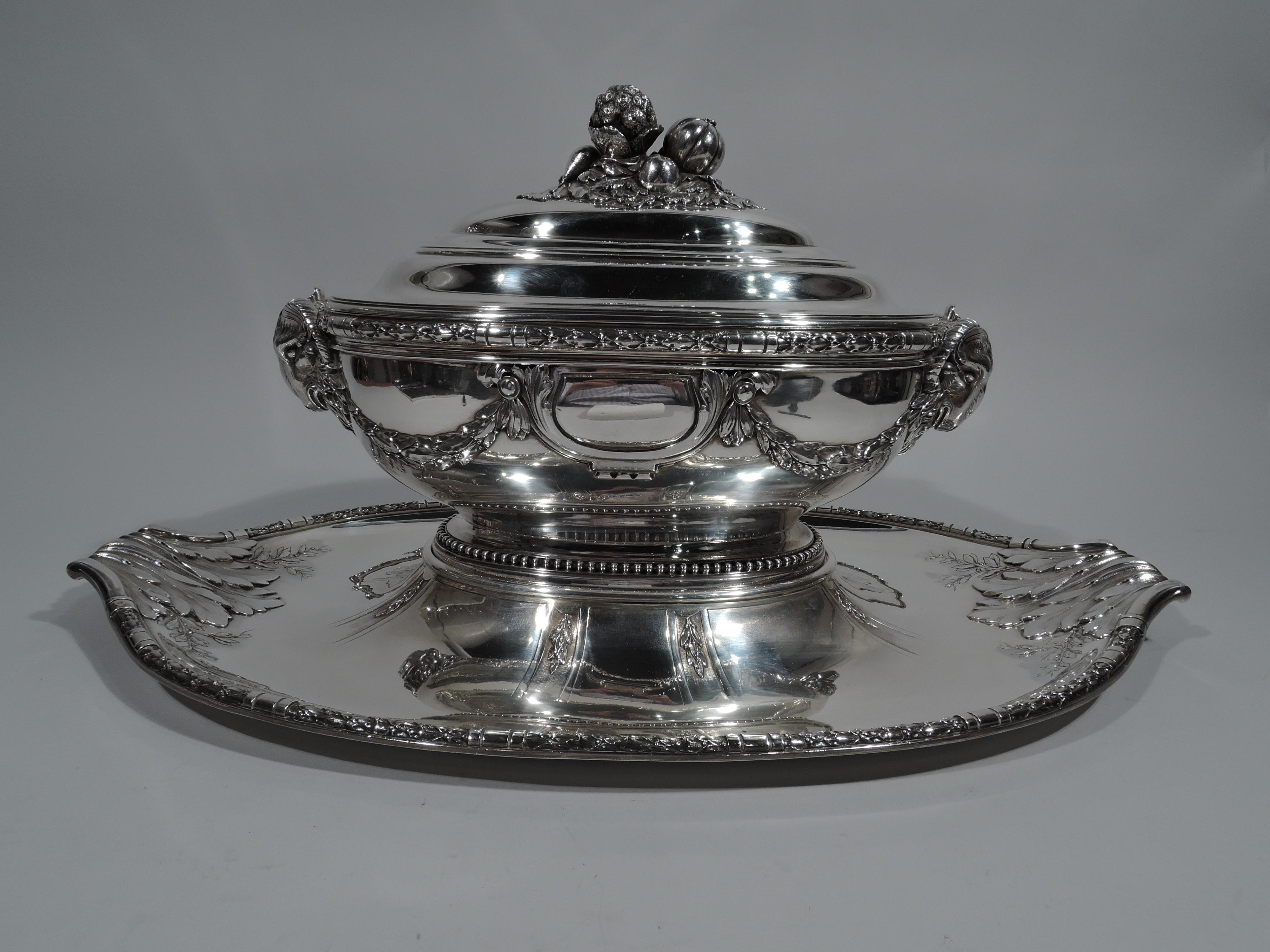 Large Belle Époque 950 silver tureen on stand. Made by Claude Doutre Roussel in Paris, circa 1900.

Tureen: Ovoid with curved sides and raised foot. Cast ram head end mounts and applied imbricated leaf swag. Two shaped and scrolled frames (vacant).