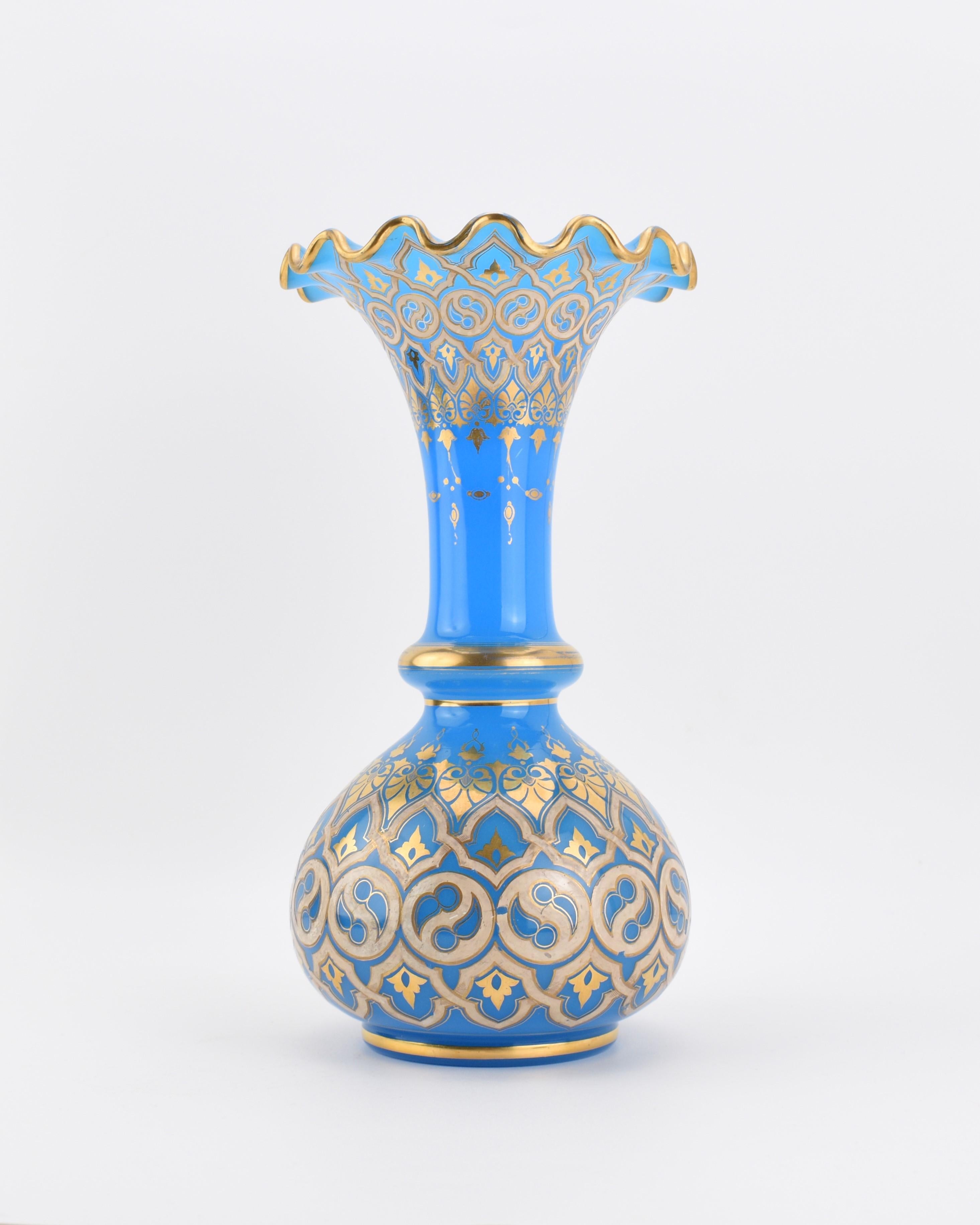 Blue opaline glass vase by Baccarat

Circular body, hand-painted all around with gilded enamel and 24k matte and burnished gold highlights forming symmetrical shapes and patterns

further enamel decoration on the neck, gilded wavy rim

France, circa