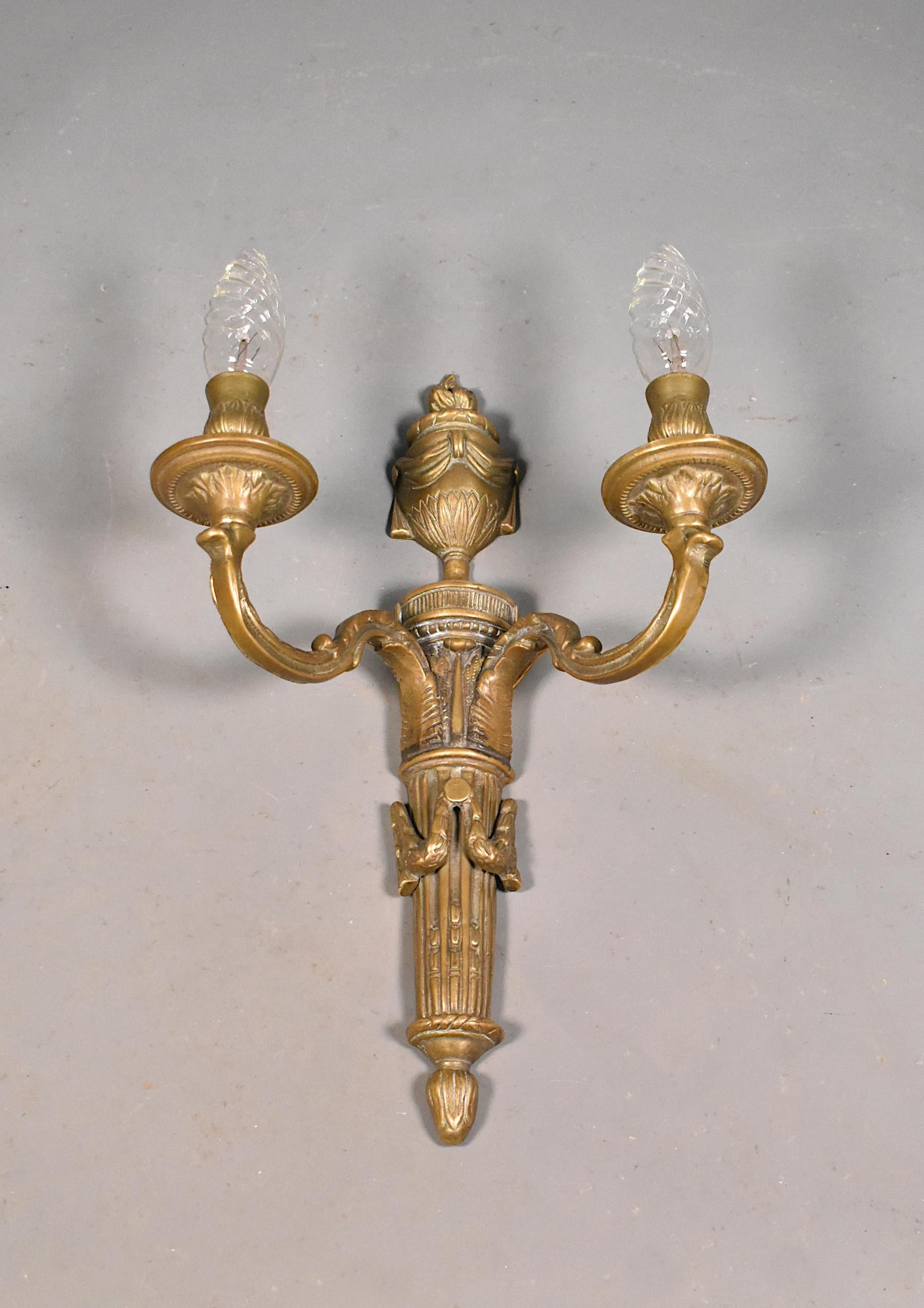 Large antique French bronze wall sconce Napoleon III (19th Century).

This large decorative wall sconce in bronze features out-swept arms with floral detail. The arms support two decorative candle lights. 

To the top is an urn draped in swags