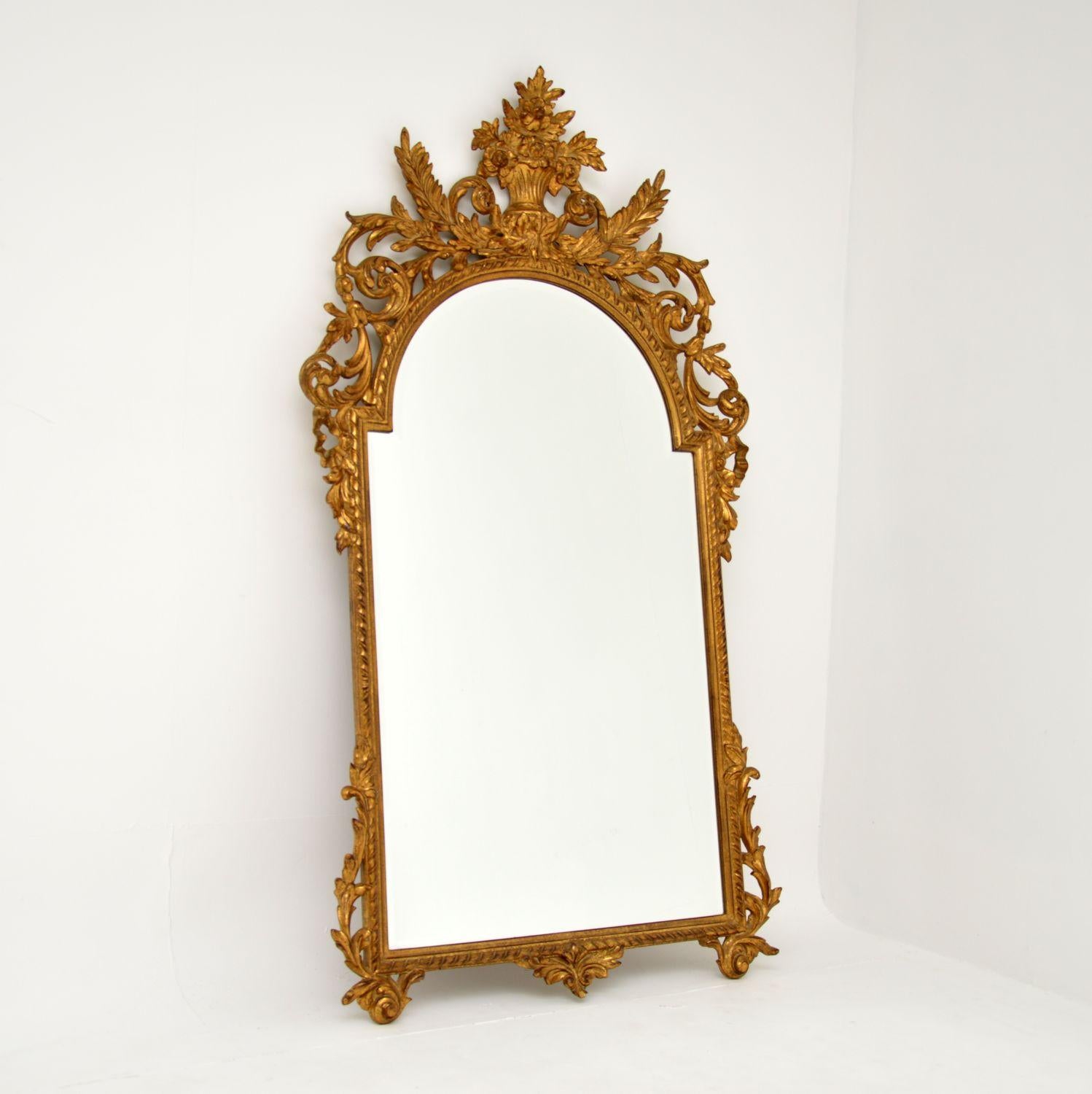A large and impressive antique carved gilt wood mirror, which I would say is French, dating from around the 1950’s period.

It is beautifully made and has a stunning design. There is intricate floral carving throughout, this is beautifully gilded