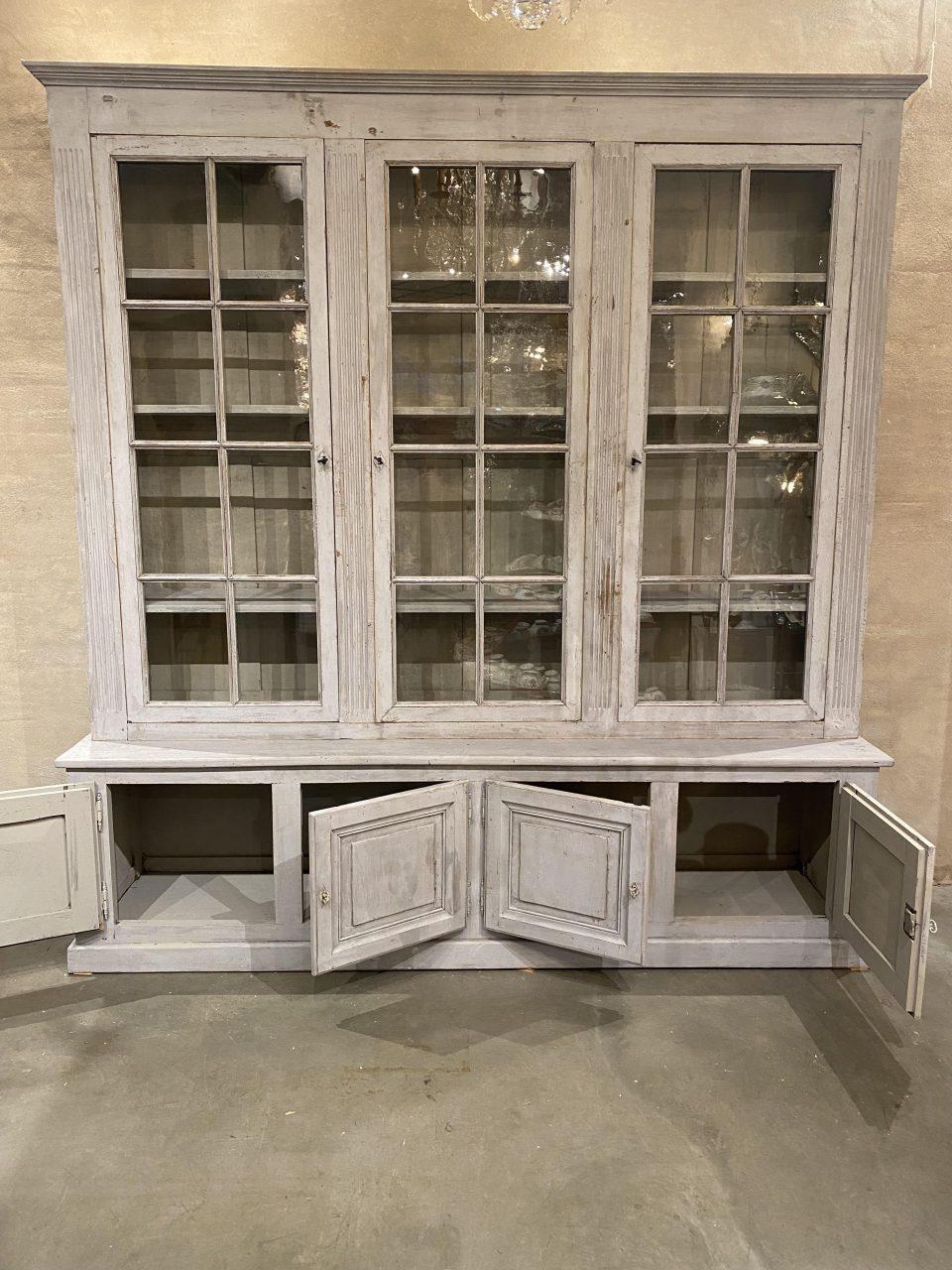 Incredible, large, elegant and handsome antique French two-part bookcase/vitrine cabinet.

The upper part of the cabinet consists display case with 3 double paned glass doors, in which the old glass is preserved, and with charming fluted profiles
