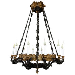 Un grande lampadario antico in stile impero francese in bronzo dorato e bronzo patinato