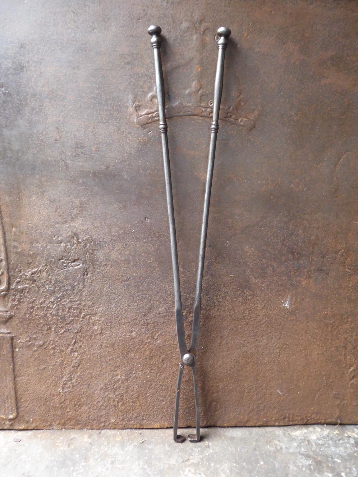 Large late 18th or early 19th century French neoclassical fireplace tongs. The tongs are hand forged and made of wrought iron. The fire tongs are in a good condition and are fully functional.