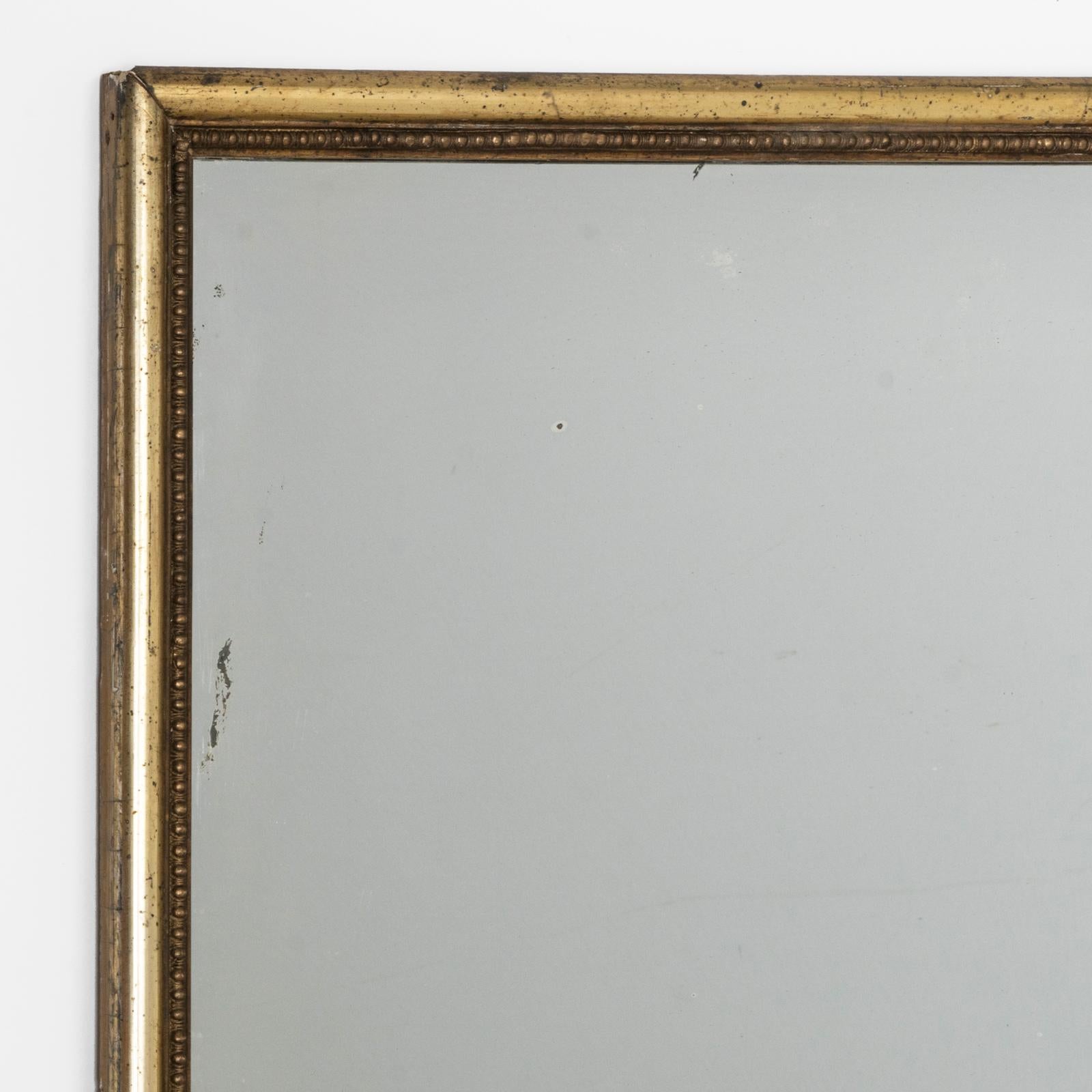 Ein großartiger französischer rechteckiger Spiegel aus Giltwood aus der Jahrhundertwende um 1900 mit einem anmutig subtilen goldenen Rahmen.

Das Spiegelglas trägt einen Hauch von Charakter in Form von ein paar charmanten kleinen Flecken. Diese