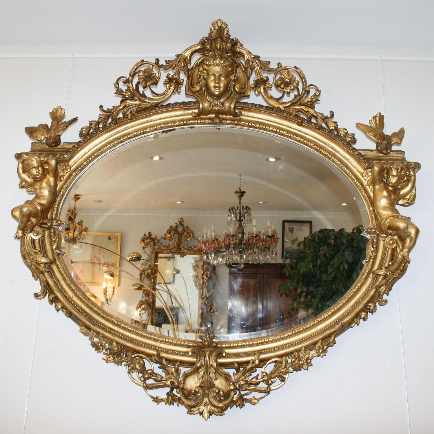 This very large antique giltwood and gesso mirror has some fabulous details, but unfortunately the images do not do it justice and it really needs to be seen in person.

It’s early to mid-19th century, either French or Italian and has the original
