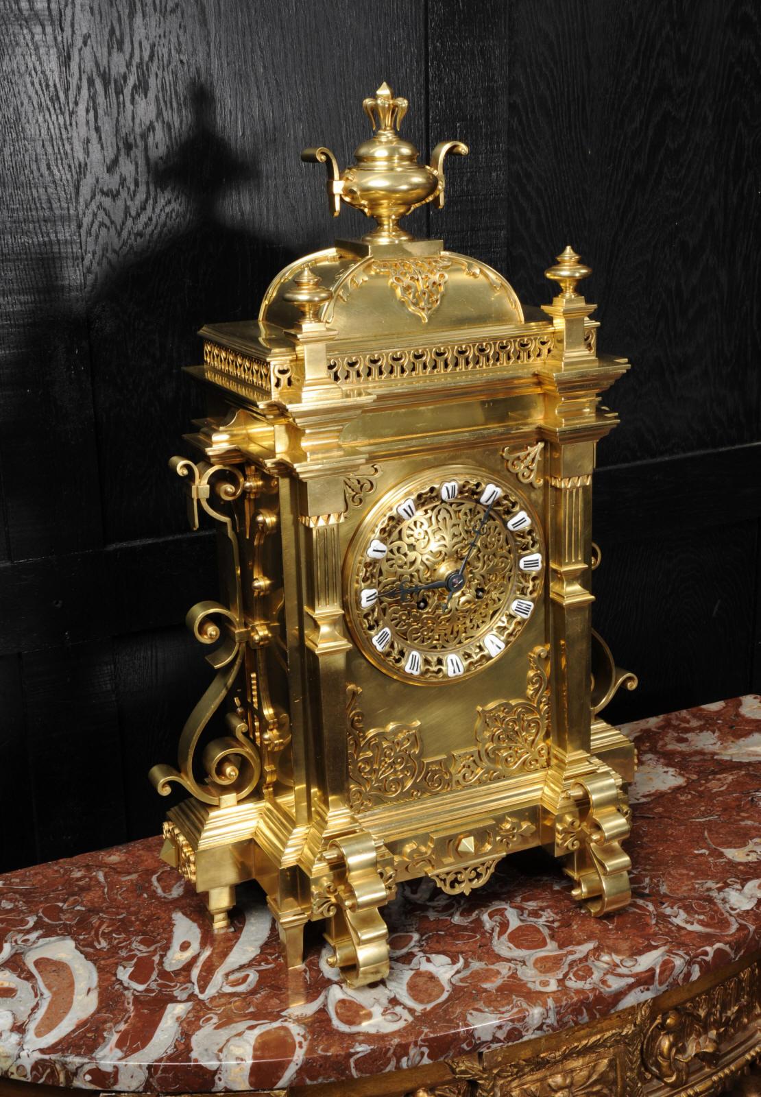 A very large antique French clock in the Gothic style. It is of exquisite quality in gilt bronze, architectural in design with a domed top, blind fret work decoration and scrolling brackets to the sides. The detail is beautifully finished and well