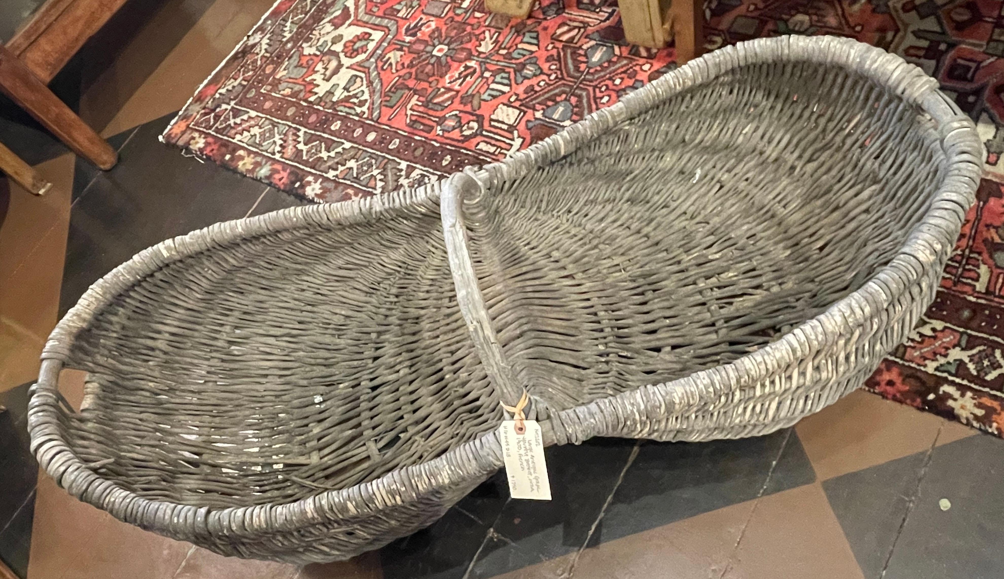 Lovely large sized grape harvesting/gathering basket from the Burgundy region of France. Handwoven with wicker over wooden frame, with central arched carrying handle. Old weathered surface, great structural condition, circa 1900.