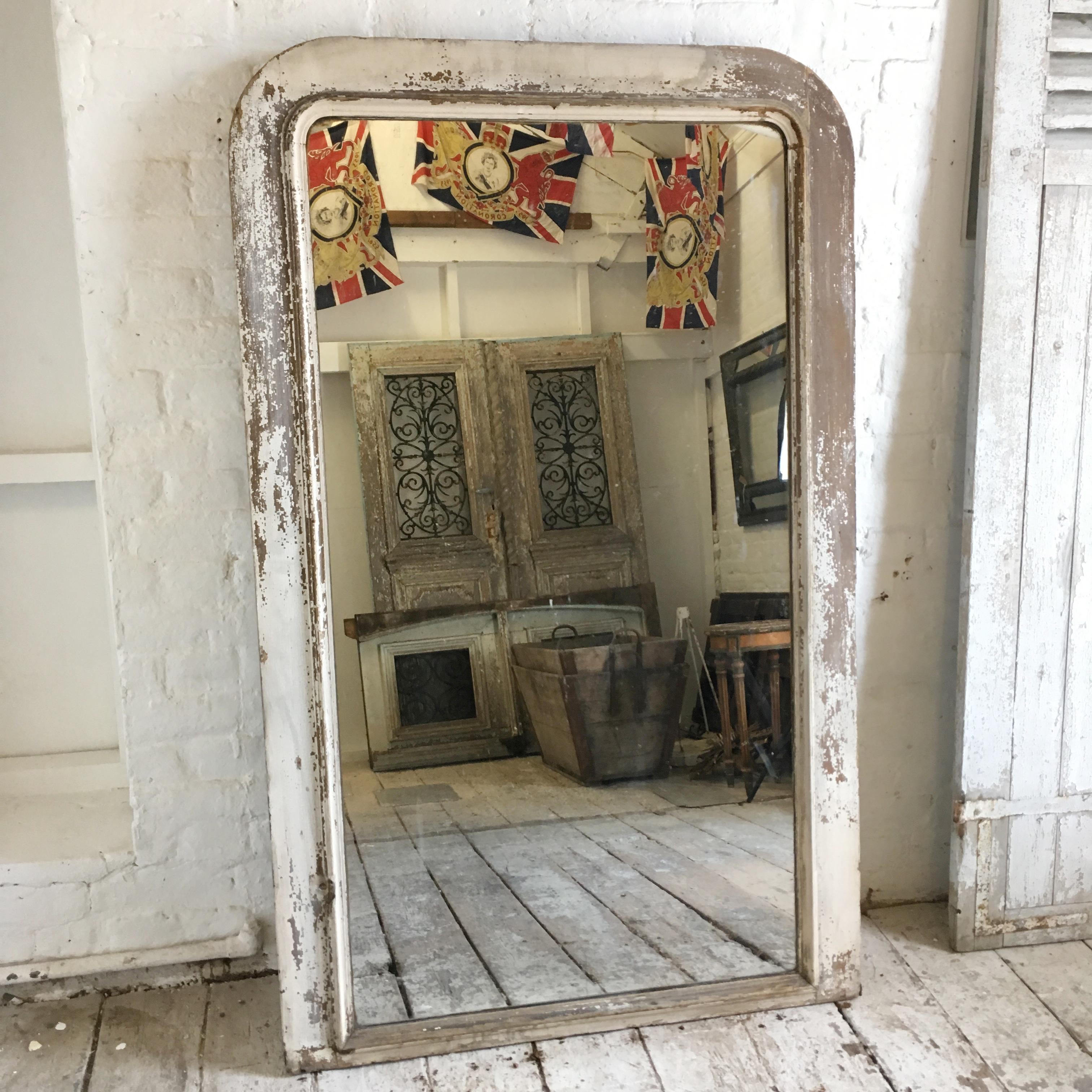 Large antique wooden framed French Louis over mantle mirror. 19th century. Wooden frame with original soft white paint, worn to a beautiful patina. The back of the mirror has a beautiful beaded edge wooden single back panel, unusual for these