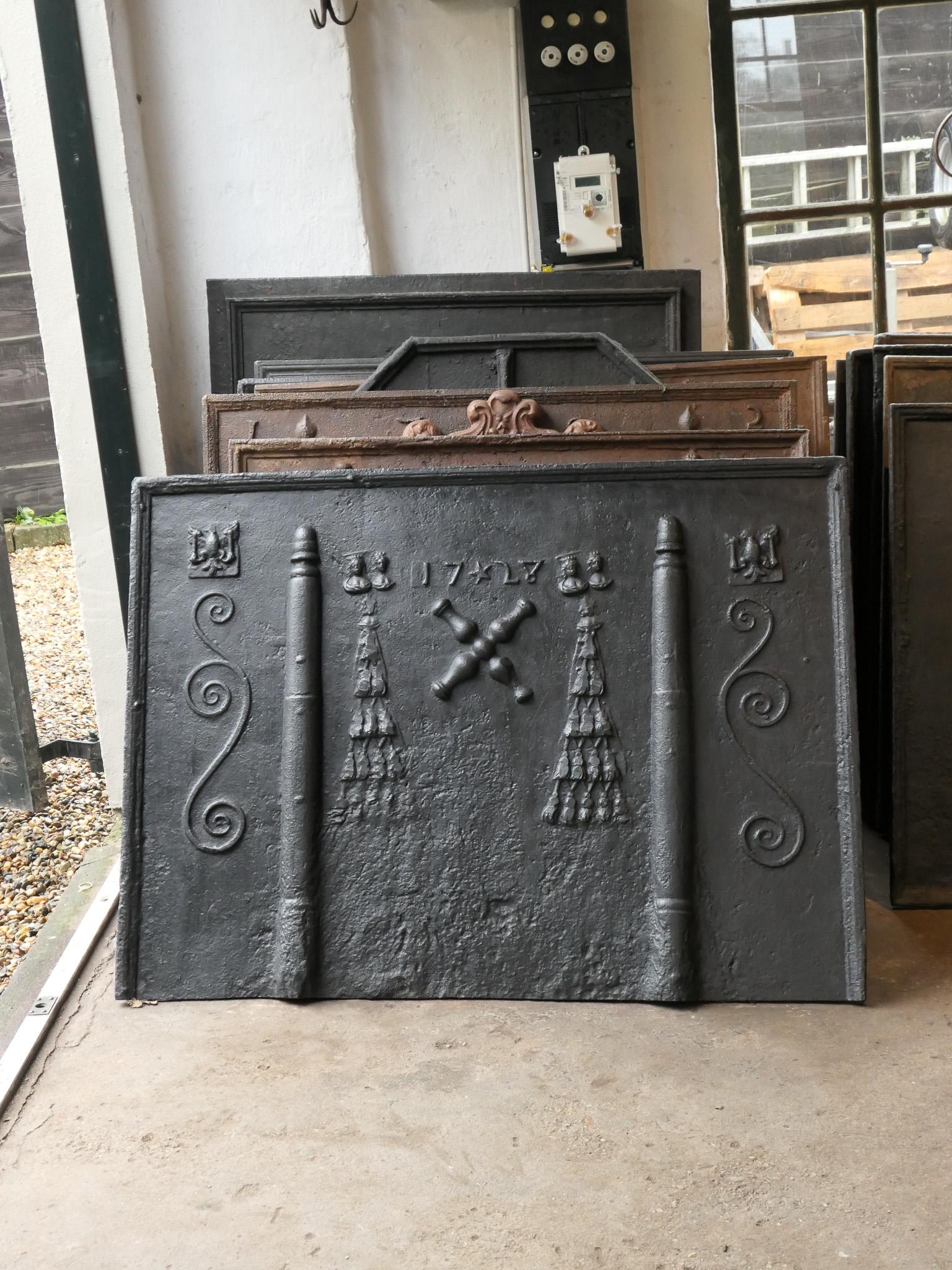 Beautiful 18th century French Louis XIV period fireback with a coat of arms. The fireback is decorated with two pillars and a Saint Andrew's Cross in the center.

The fireback is made of cast iron and has a black / pewter patina. It is in a good