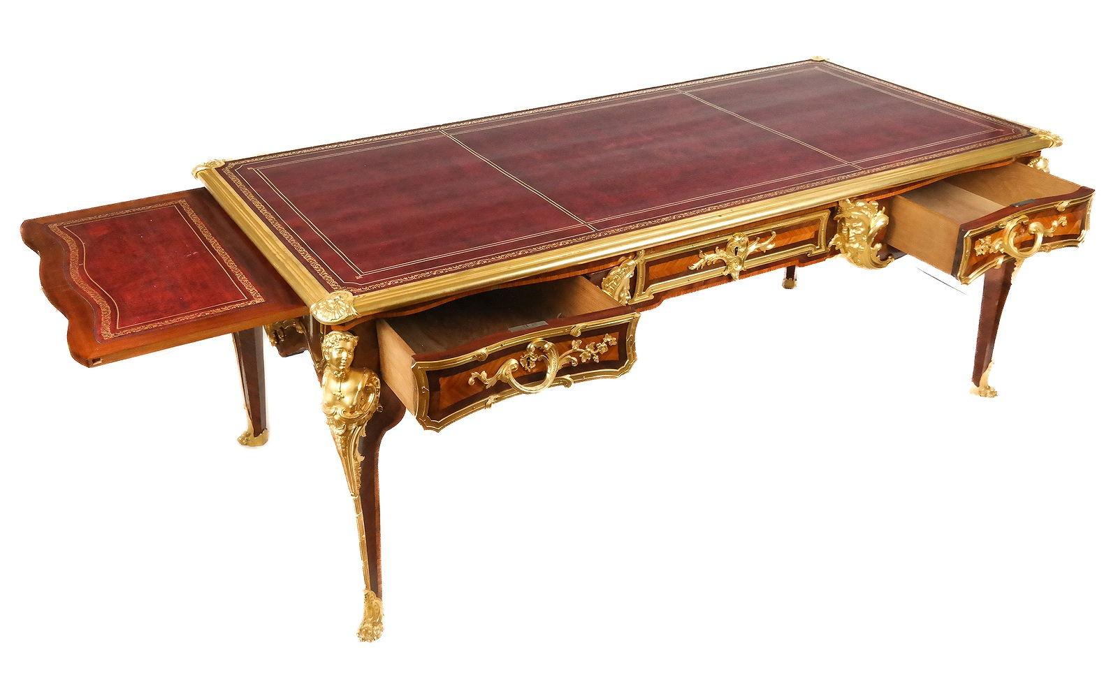 Monumental antique bureau plat (desk) in the French Louis XV style after the original design by Charles Cressent (1685-1768), 80 by 38 by 32.5 inches, finely crafted with kingwood and tulipwood veneers with finely modeled, cast and gilt bronze