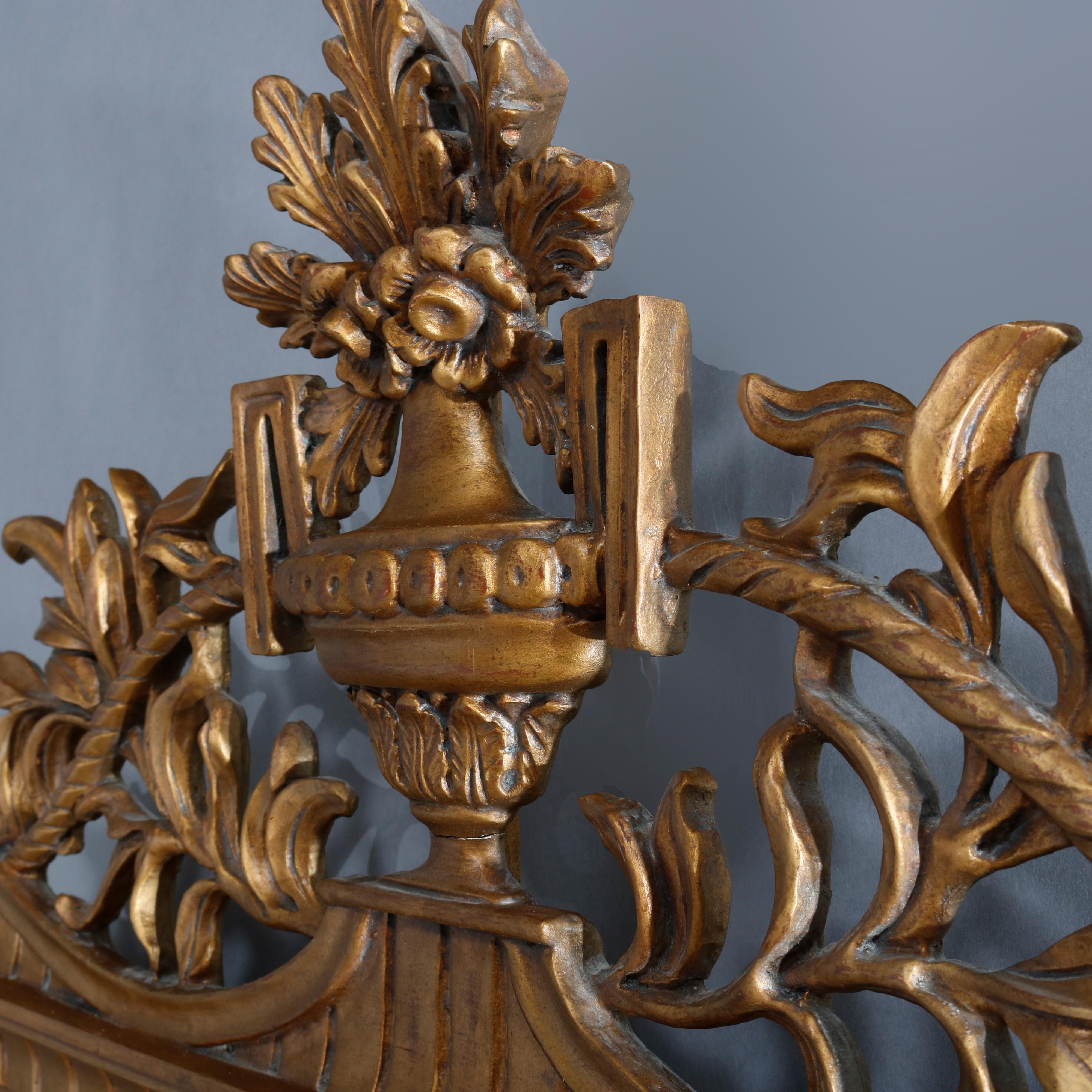 A large antique French Louis XVI wall mirror offers carved giltwood frame having pierced palmette urn form crest and foliate Greek key, beaded and dental molding elements, 20th century

Measures: 57.75