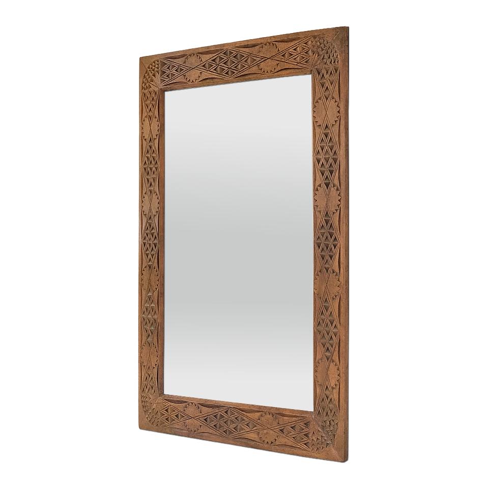 Antique French mirror from the 1920s in hand-carved limewood. Notched and scored carving wood with geometric decorations in Oriental style. Frame width: 10 cm / 3.93 in. Modern glass mirror. Wooden rear panel.