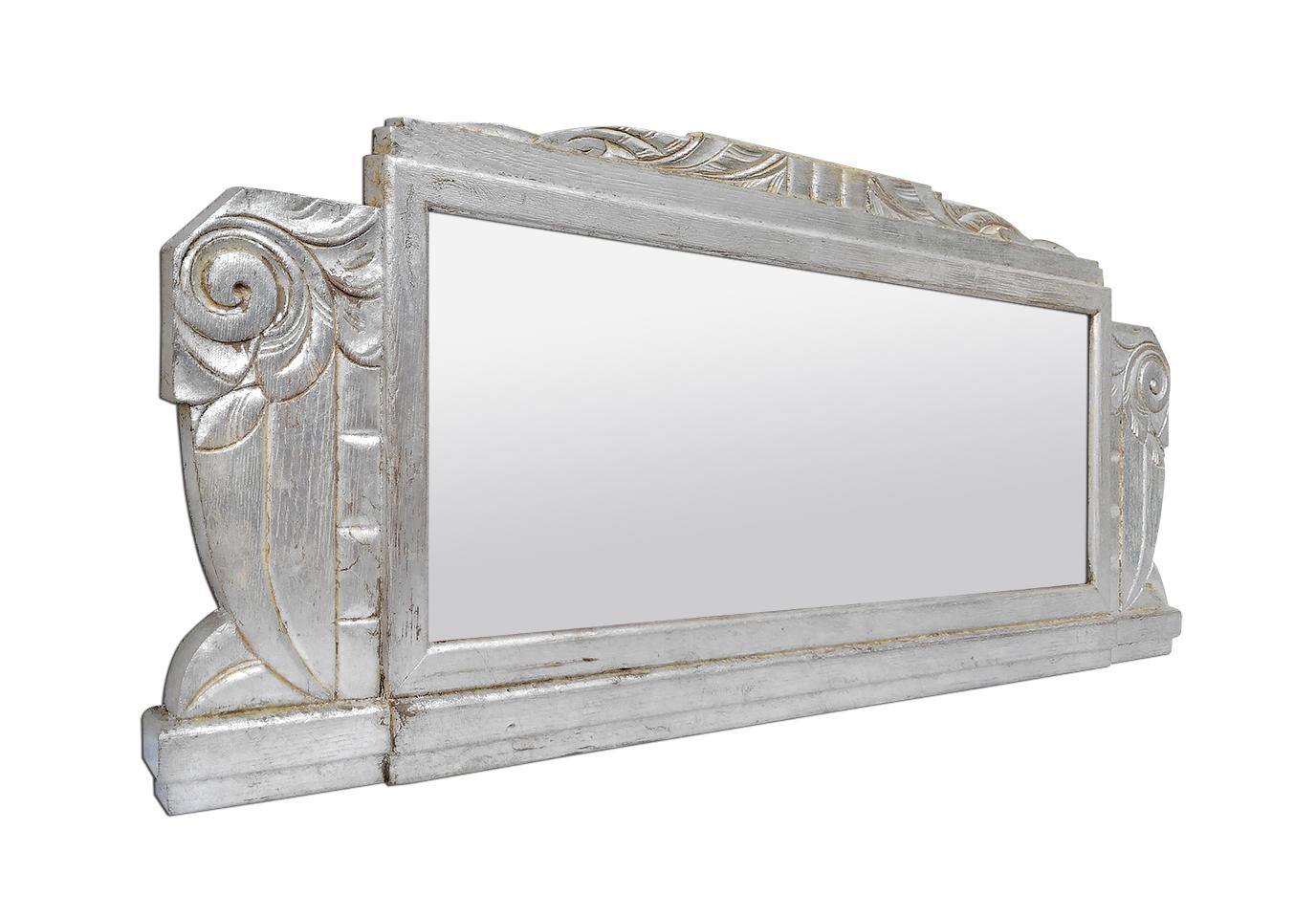 Large antique french wall mirror in carved silvered oak wood with Art Deco style ornaments, circa 1940. Re-gilding to the leaf patinated. Antique frame width 15 cm / 5.90 in. Modern glass mirror. Antique wood back.