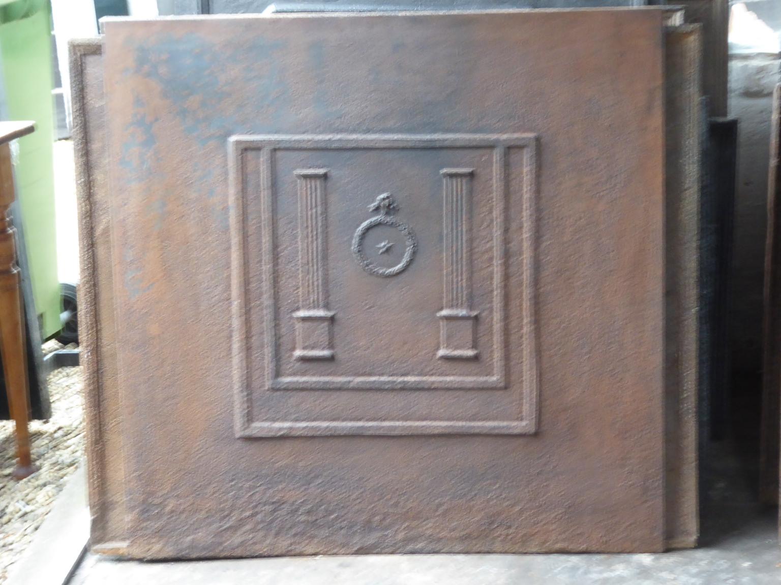 19th century French neoclassical fireback with two pillars of freedom. The pillars symbolize the value liberty, one of the three values of the French revolution. 

The fireback is made of cast iron and has a natural brown patina. Upon request it can