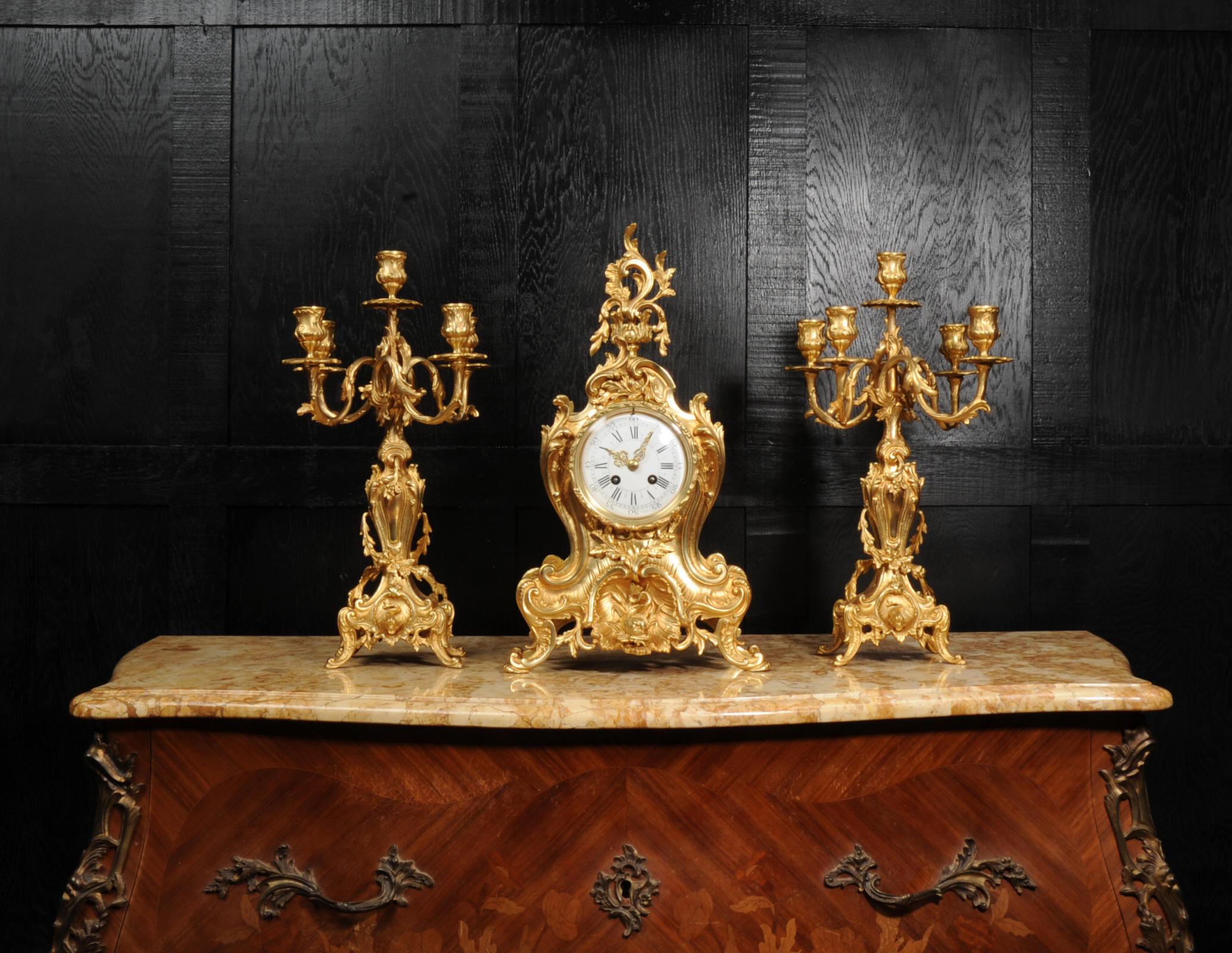A stunning and large original antique French ormolu clock set by A. D. Mougin. It is of the most beautiful Rococo style, featuring a dolphin in a niche, and decorated with 'C' scrolls, acanthus leaves, laurel sprigs and floral swags. Candelabra have