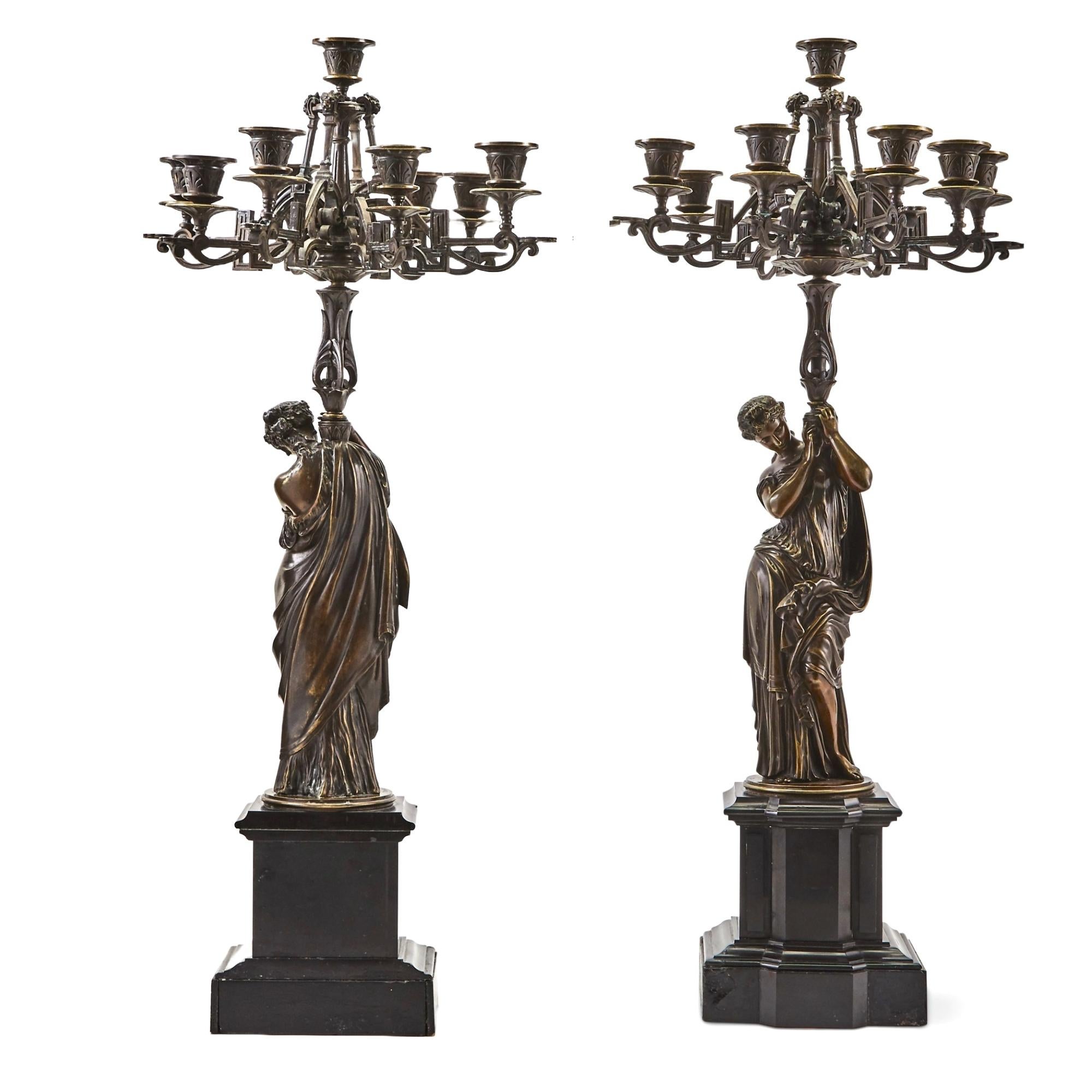 This magnificent pair of large 19th-century French candelabras, inspired by Moreau, combines classical beauty with exceptional craftsmanship. Each candelabra is crafted in patinated bronze with gilt accents and showcases a goddess dressed in flowing
