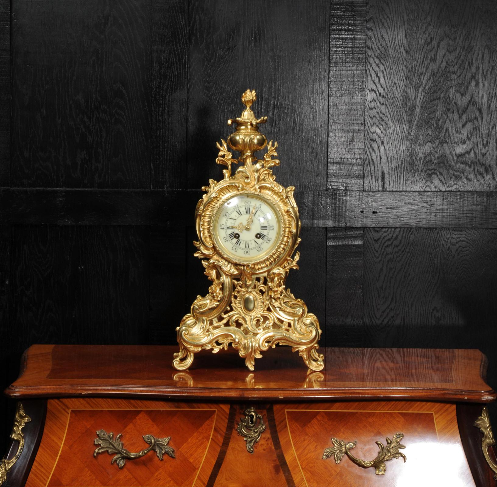 Eine große, prächtige und sehr dekorative original antike französische Uhr aus der Zeit um 1900. Sie ist im Stil des Rokoko in feiner vergoldeter Bronze ausgeführt. Tailliertes Gehäuse, reich verziert mit Akanthusblättern und 