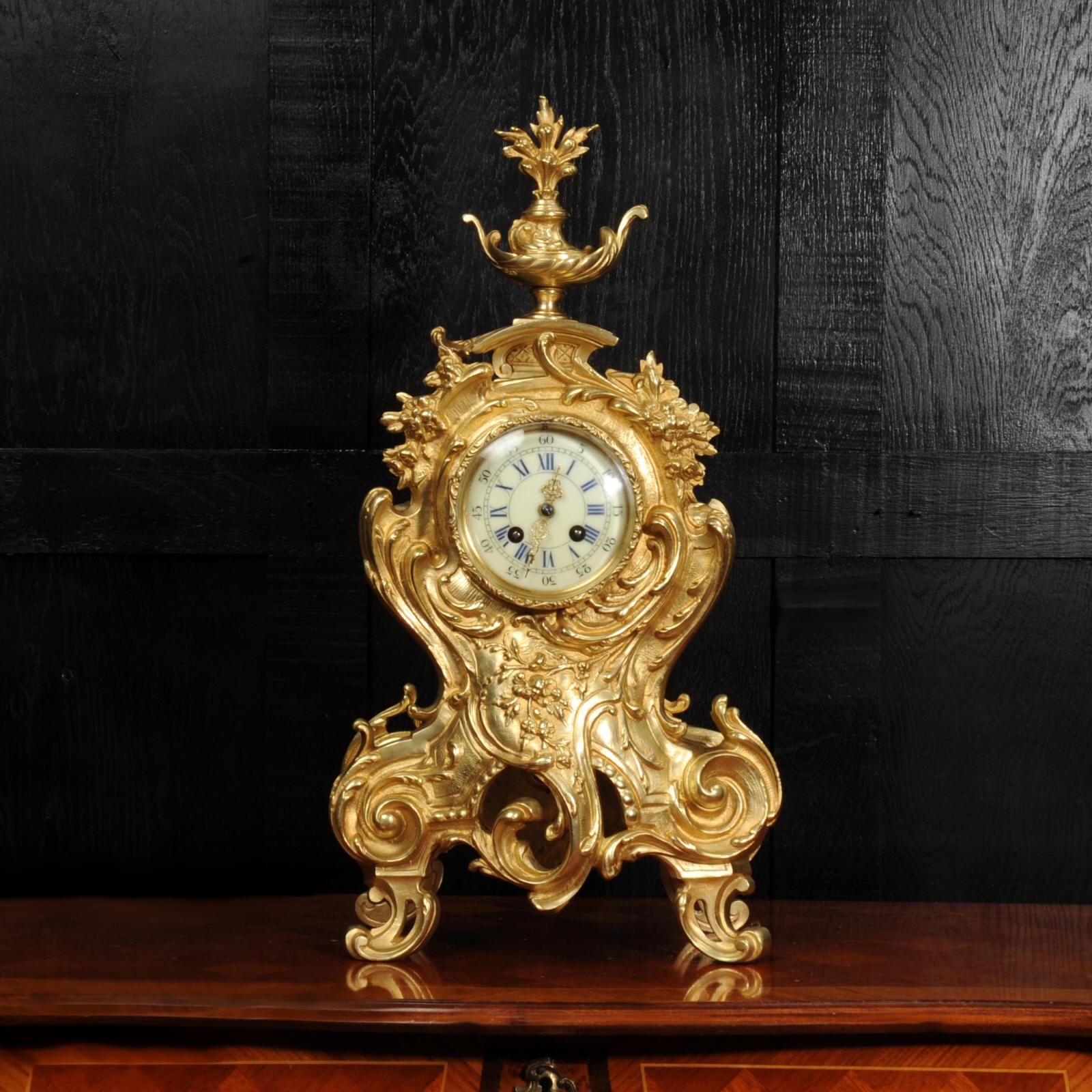 A stunning original antique French Rococo clock by A. D. Mougin. Boldly modelled balloon shape, profusely decorated with scrolls, acanthus and floral swags. To the top is a large elaborate final of a stylised flaming lamp. A pieced panel to the