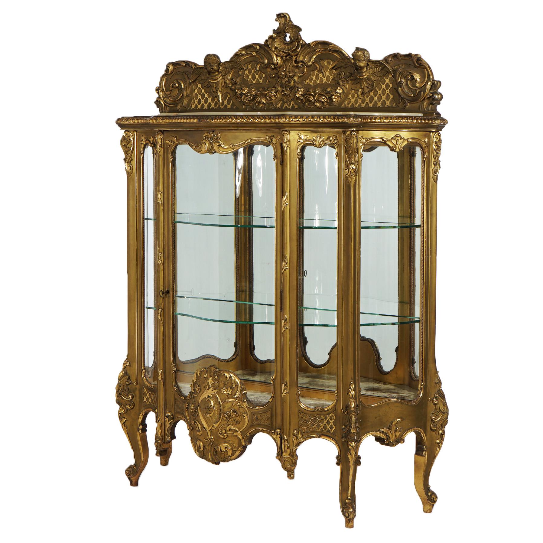 ***Ask About Reduced In-House Shipping Rates - Reliable Service & Fully Insured***
Oversized antique French Rococo display vitrine offers giltwood construction with figural crest over marble top shaped case having single glass door opening to