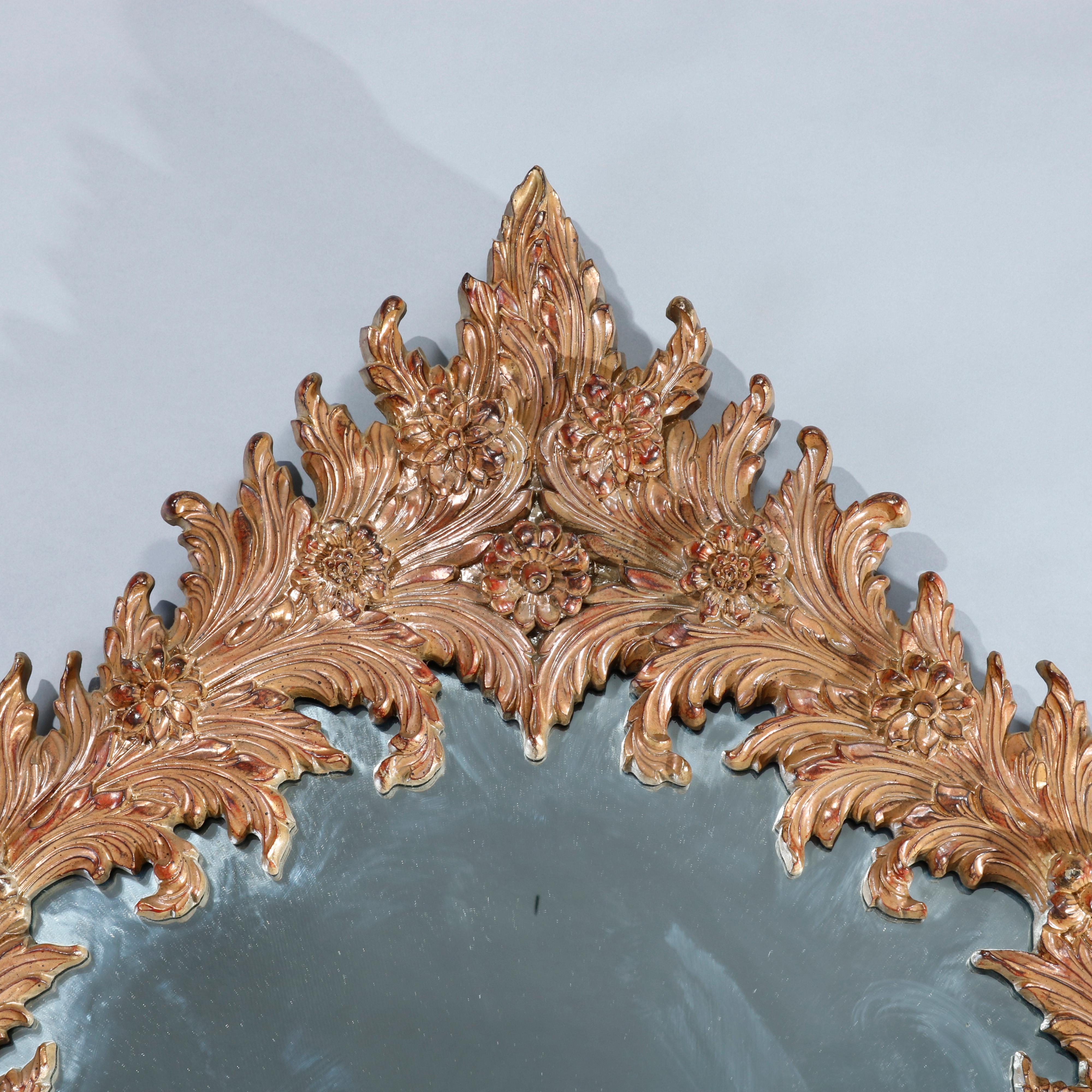 An antique and large French Rococo wall mirror offers oval giltwood foliate and floral form frame, 20th century

Measures: 52