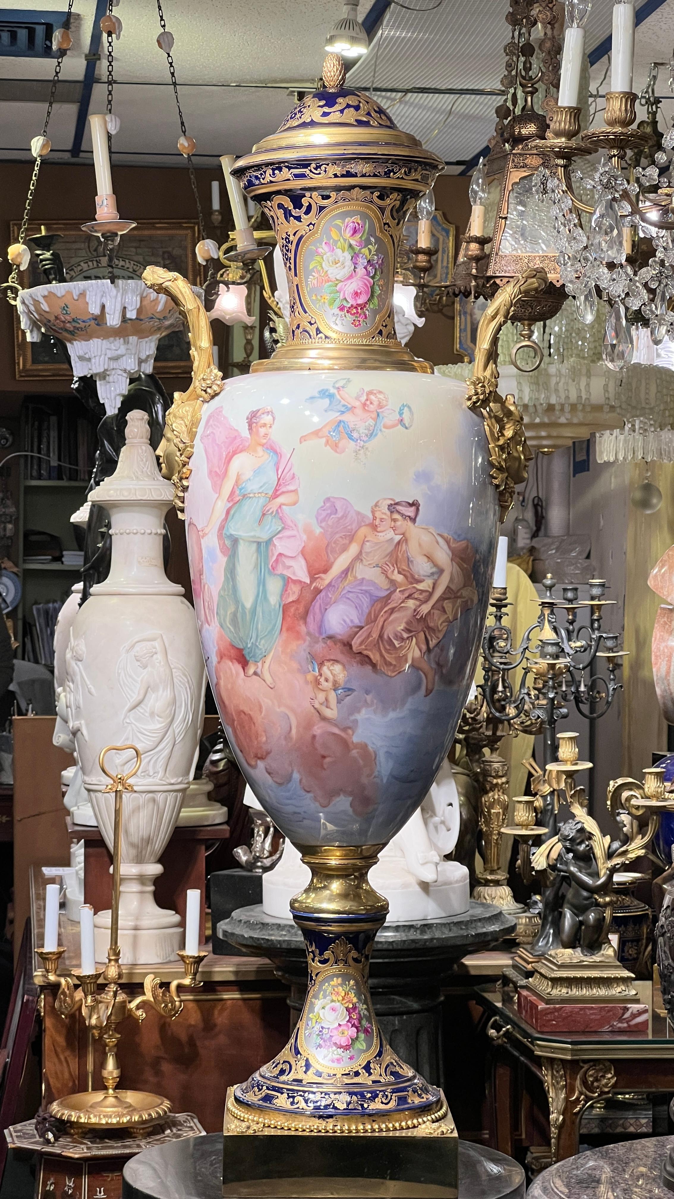 Finest quality Palace size  (50 inch tall) French Sevres style porcelain vase with gilt bronze mounts depicting the Roman goddess of fertility and motherhood, motioning to her attendants and cherubs nearby and pointing to her chariot.  Signed E.