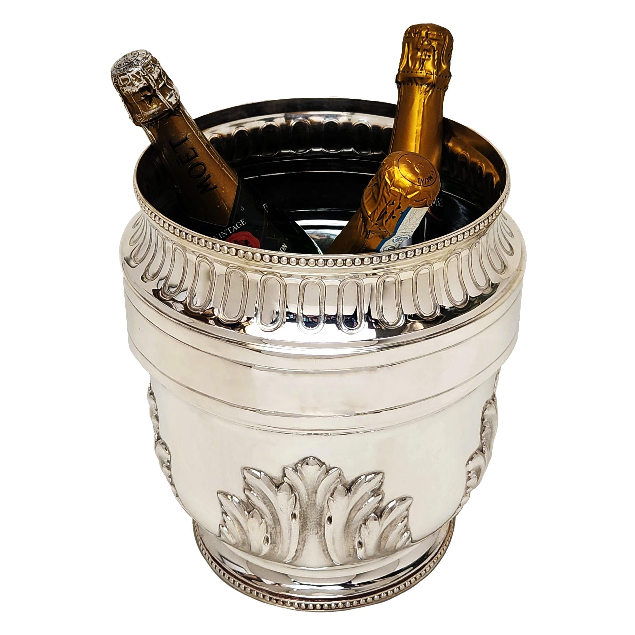 A Large Antique French Silver Wine Cooler decorated with a chased stylised leaf design and with a a pair of leaf bordered cartouches. The upper and lower rim of the Cooler is embellished with a classic bead border.

Made in France in c.