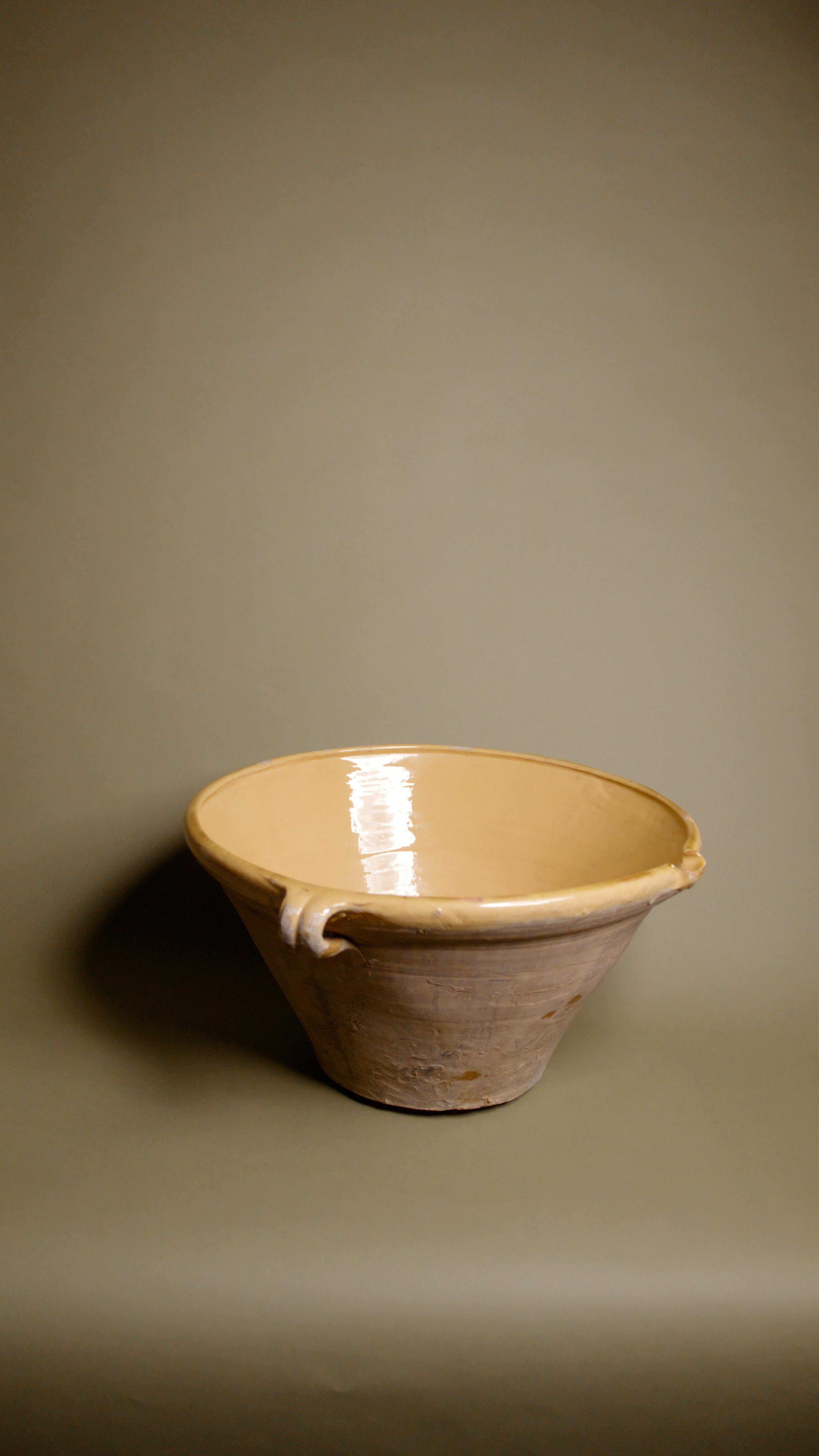 Ejemplo intemporal de la artesanía rural francesa, este gran cuenco francés antiguo de terracota Tian es una pieza de barro bellamente envejecida con una rica historia. Utilizado originalmente en las cocinas provinciales francesas para mezclar,