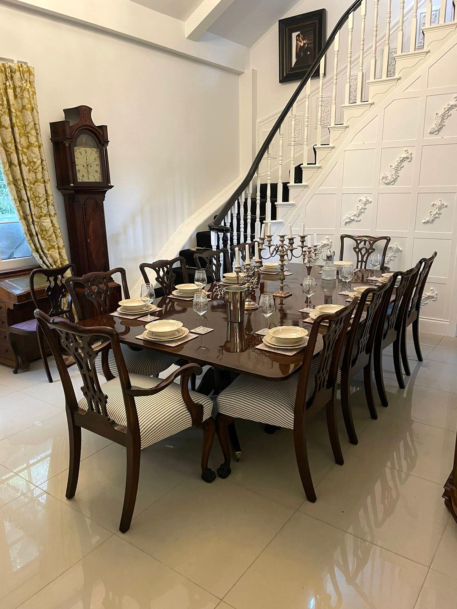 Grande tavolo da pranzo a tre pilastri in mogano figurato di qualità eccezionale di George III, con un magnifico piano in mogano figurato di qualità in tre sezioni sostenuto da tre favolose colonne con piedistallo tornito che poggiano su quattro