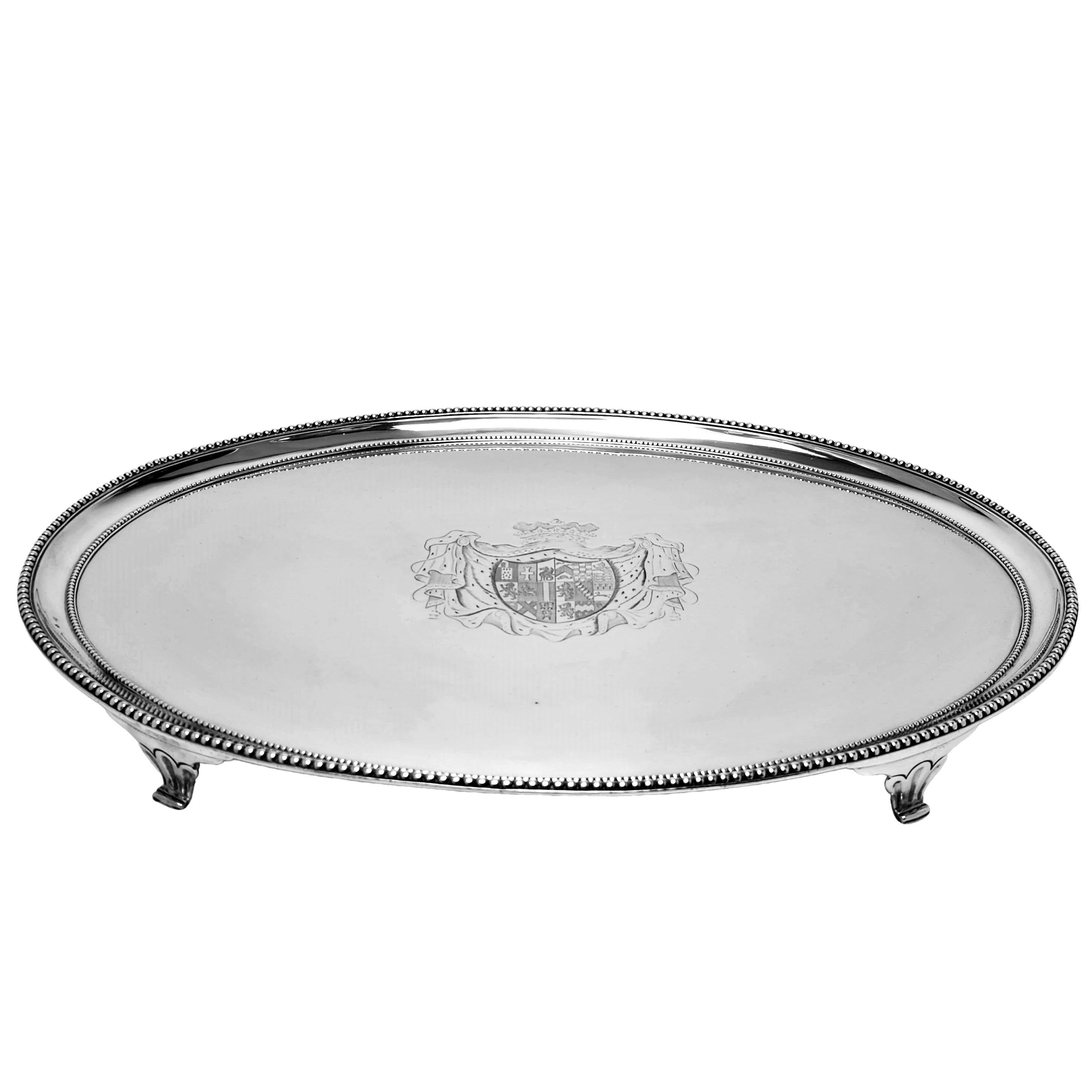 An impressive Antique sterling Silver Salver in an elegant oval shape and standing on four feet. The Salver has large armorial engraved in the centre and the Salver has a classic applied bead border on the top and bottom of the rim.

This Salver is