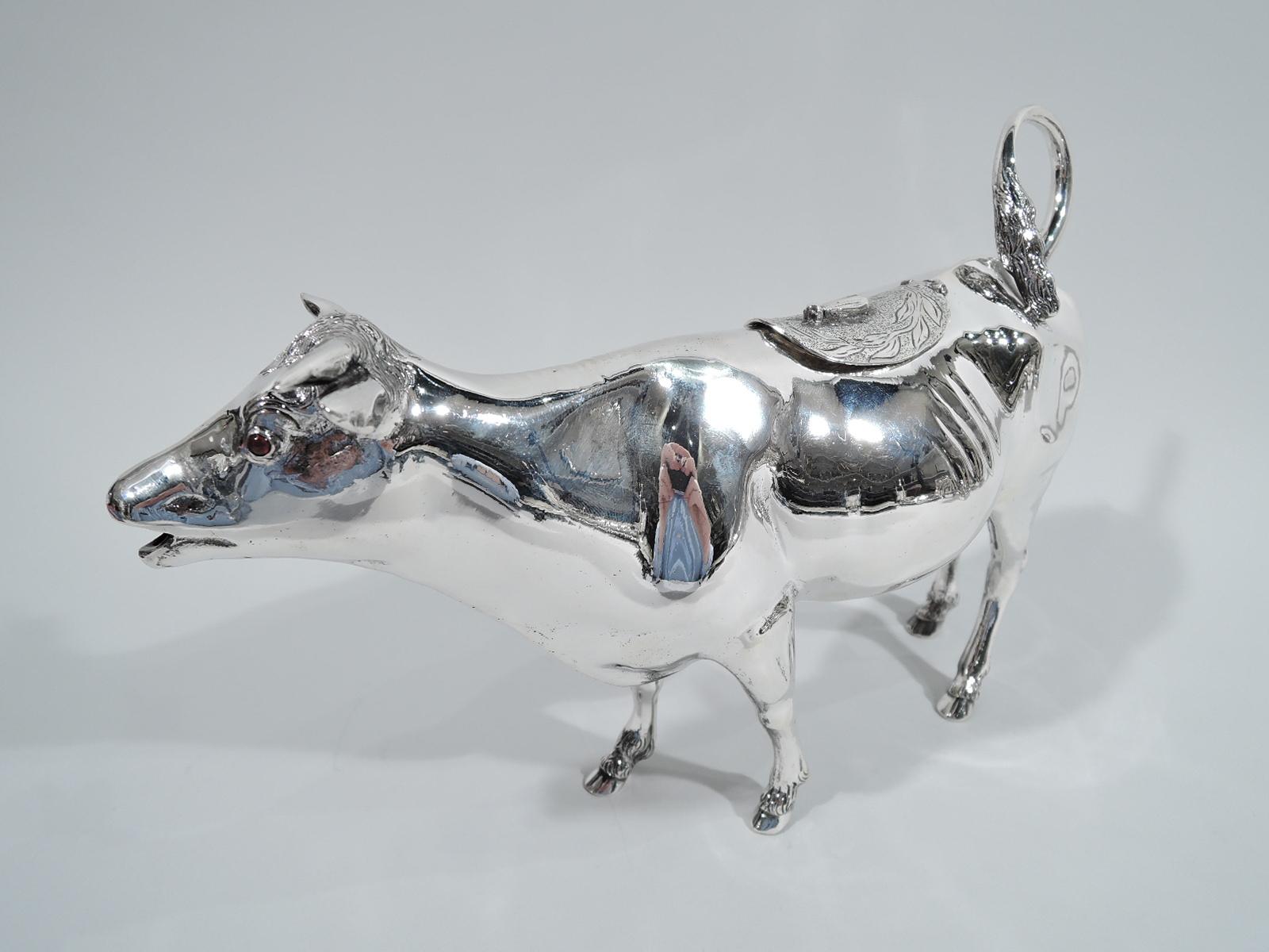 Turn-of-the-century German 800 silver cow creamer. Imported to the United States by Buchholz & Zelt in New York. Stocky body with flexed ears, flicked-back tail handle, and tooled and hinged back flap with applied fly finial. A gentle, sensitive