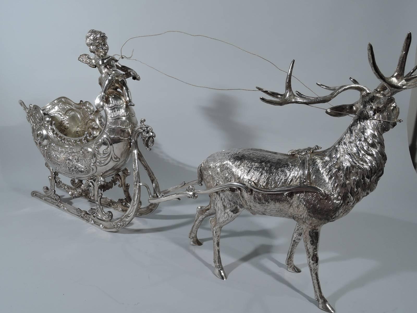 Antique German 800 silver sleigh. Ovoid with floral and diaper ornament and hunt scenes with spear-bearing men and side-saddled ladies accompanied by yapping, nipping hounds. Runners have bird’s head and applied flowers. The vehicle is piloted by a