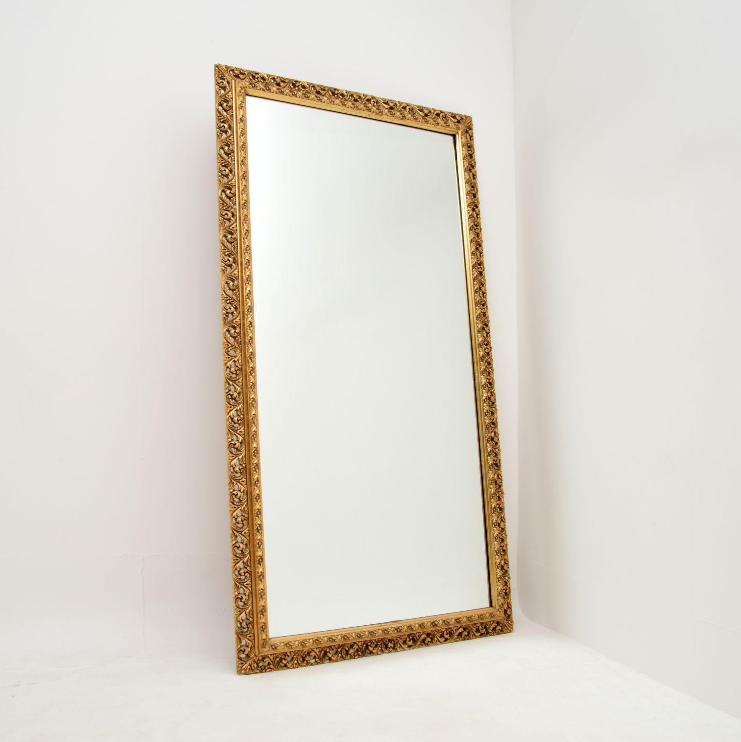A very large antique gilt wood mirror, made in England and dating from around the 1930’s.

This is of superb quality, the very large frame is solid wood with fine and intricate carved gesso on top of the wood. The gilt finish is gorgeous, with a