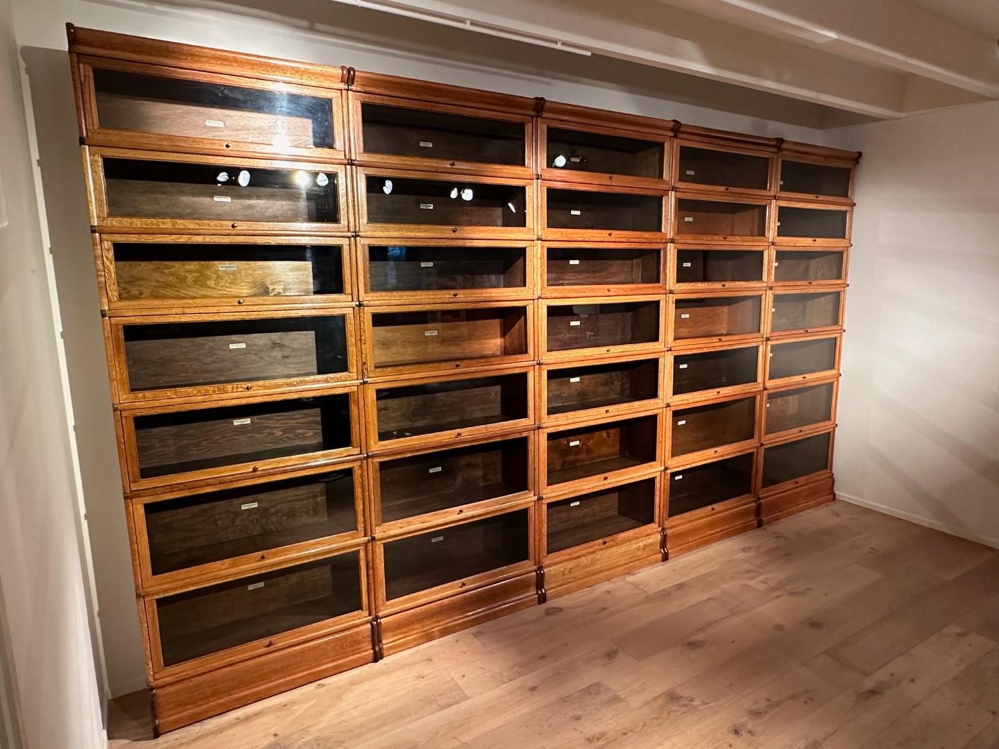 Grande bibliothèque Globe Wernicke en chêne ancien. Dans une belle couleur chêne clair. En parfait état. L'armoire est constituée de 35 éléments empilables. Les éléments peuvent être empilés à volonté. Les armoires peuvent être utilisées à des fins