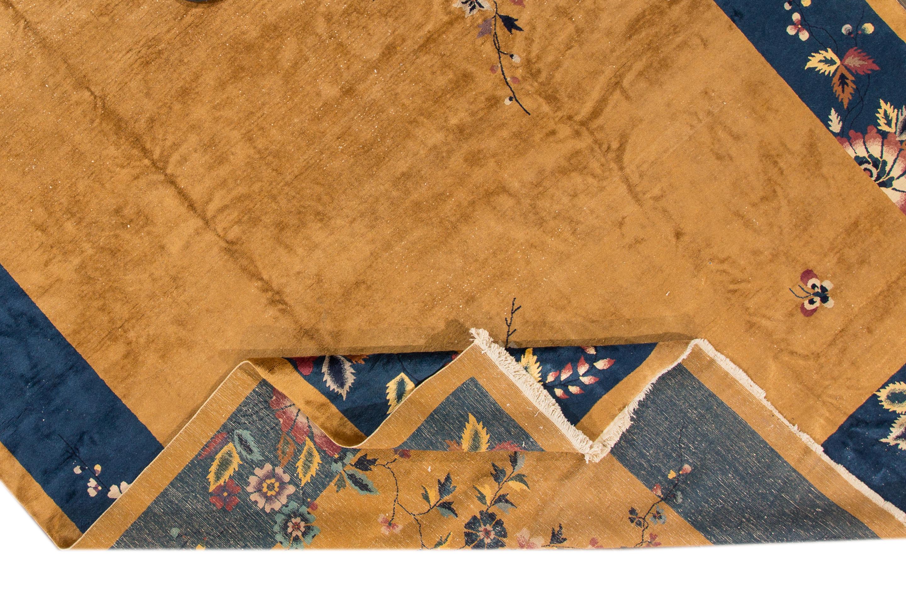 Schöner übergroßer antiker chinesischer Art-Déco-Teppich aus handgeknüpfter Wolle mit einem Feld aus Goldrute und einem marineblauen Rahmen mit einem klassischen chinesischen Blumenmuster. 

Dieser Teppich misst 12' x 17'07