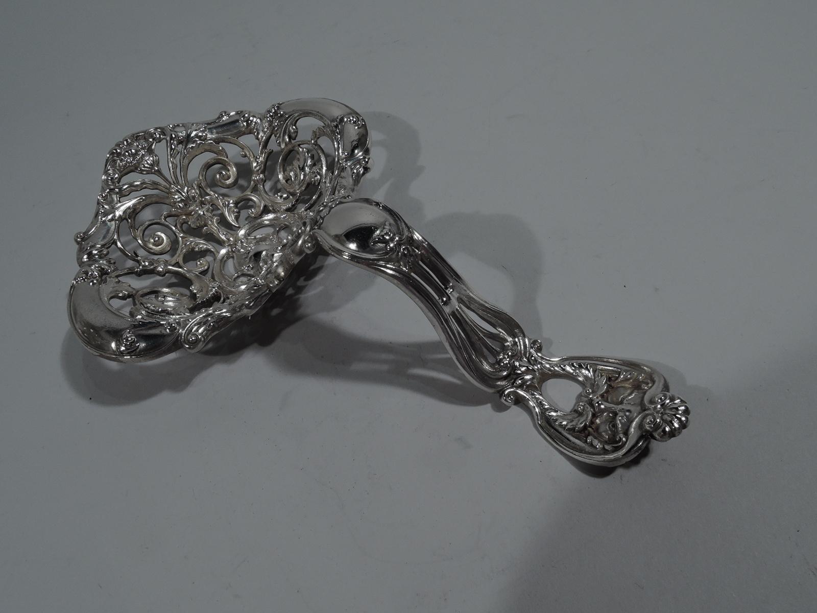 Large turn-of-the-century Classical sterling silver bonbon scoop. Made by Gorham in Providence. Wide and shaped open bowl with loose scrollwork and central strapwork cartouche (vacant). S-scroll handle with mask terminal. Fully marked including no.