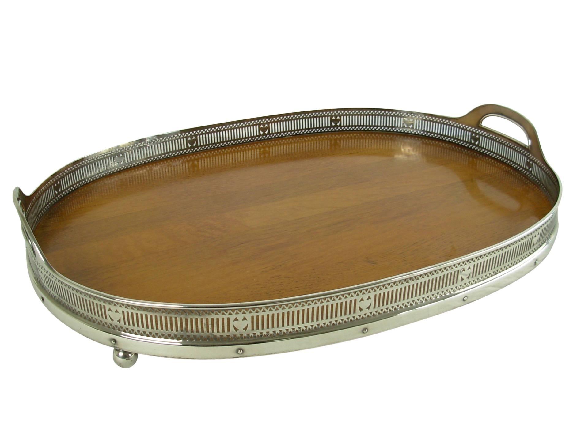 Beautiful quality and large silver-plate two handled serving tray having an inset wood bottom with pierced gallery, rising on ball feet.
Marked Gorham, late 19th century American, I believe the mark is for 1892
Measures 22 1/4