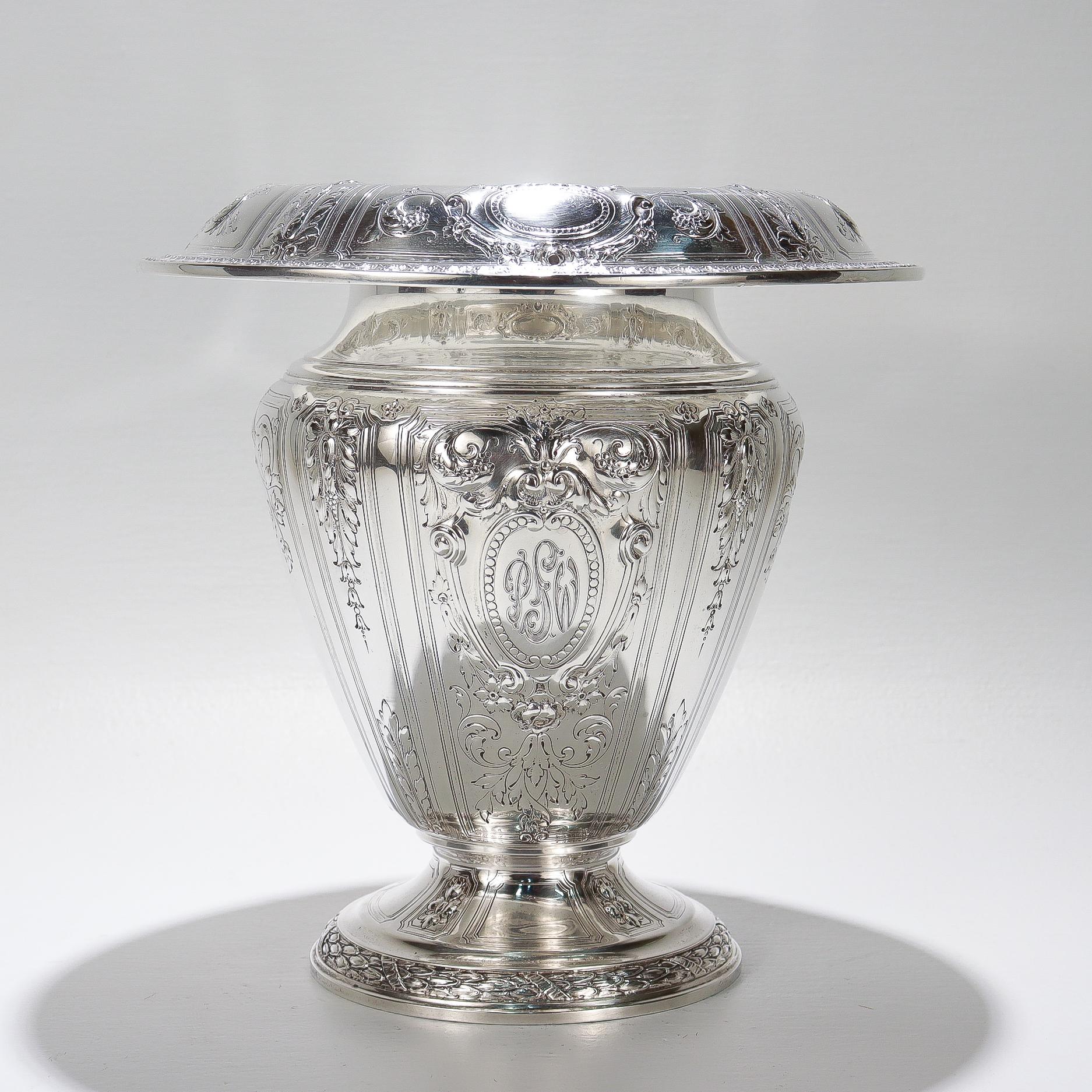 Eine schöne große antike Blumenvase.

Von Gorham.

Aus Sterlingsilber.

Nach dem Muster von Maintenon.

Mit erhabenen und gravierten Verzierungen.

Monogrammierte Kartusche auf der Vorderseite mit Monogramm, das lautet: PSW