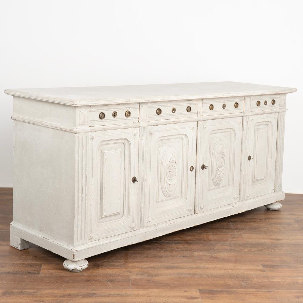 Long gray painted oak sideboard or buffet server, four drawers over four doors. 
One interior shelf inside each lower cabinet section.
Newer professionally applied layered and textured soft gray painted finish with white undertones. 
Restored,